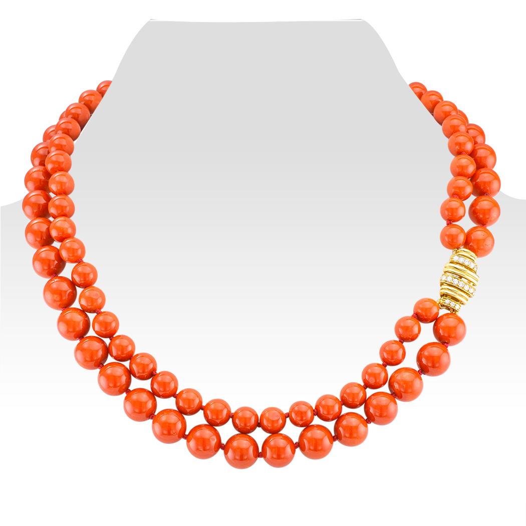 Red Coral bead diamond and gold necklace circa 1990. Comprising a pair of natural red coral bead strands, one measuring approximately 7 ½ - 8 mm; the other 9 ½ - 10 mm, in a nested design completed by an 18-karat yellow gold clasp set with fifteen