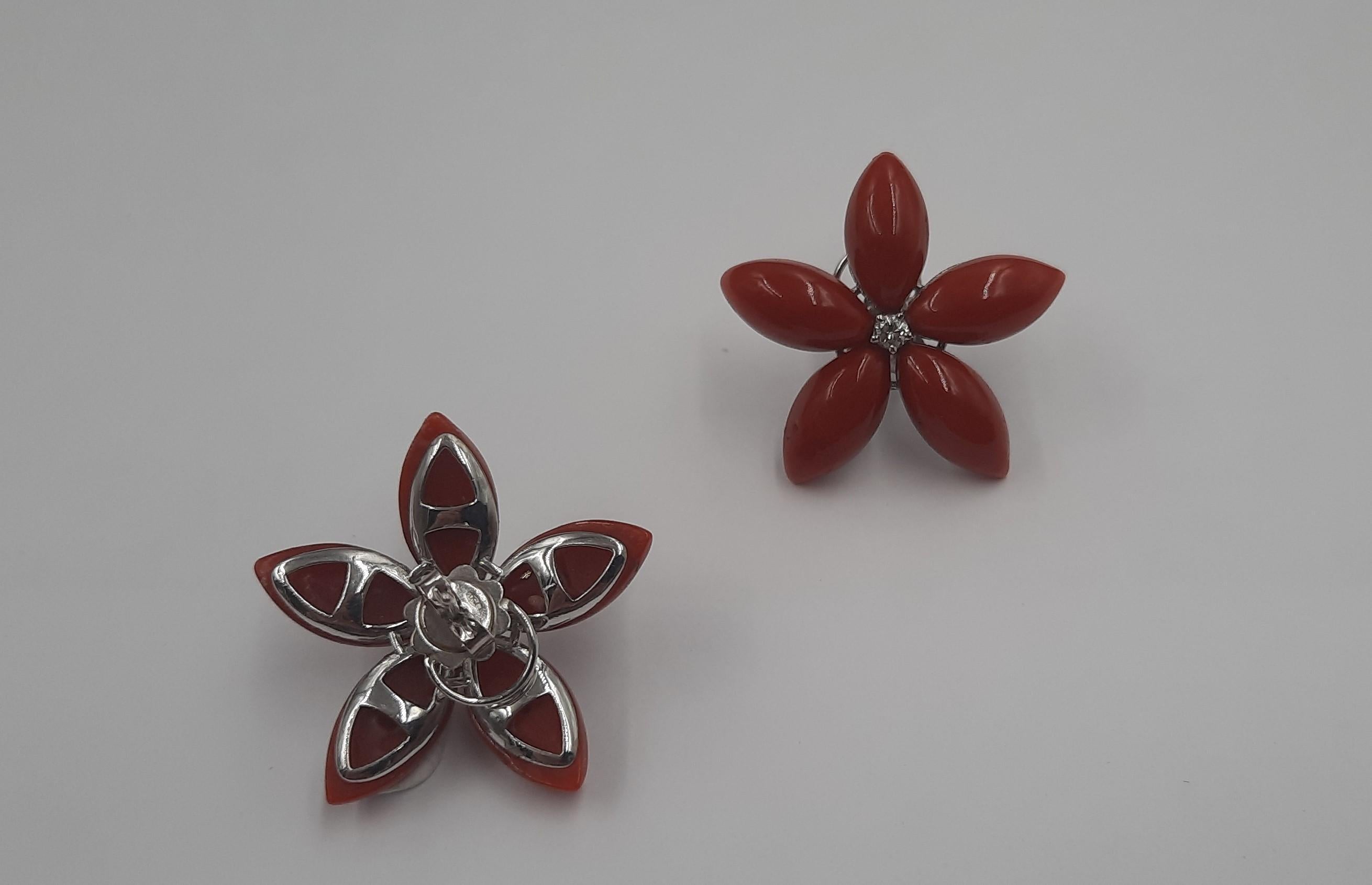 Pretty red natural coral (6 grams), brilliant cut diamond (0,18 carats) and 18 carats  white gold (4,8 grams) flower earrings. They are replicable, even smaller and with coral of a different color (for example pink). See Listings.The earrings are