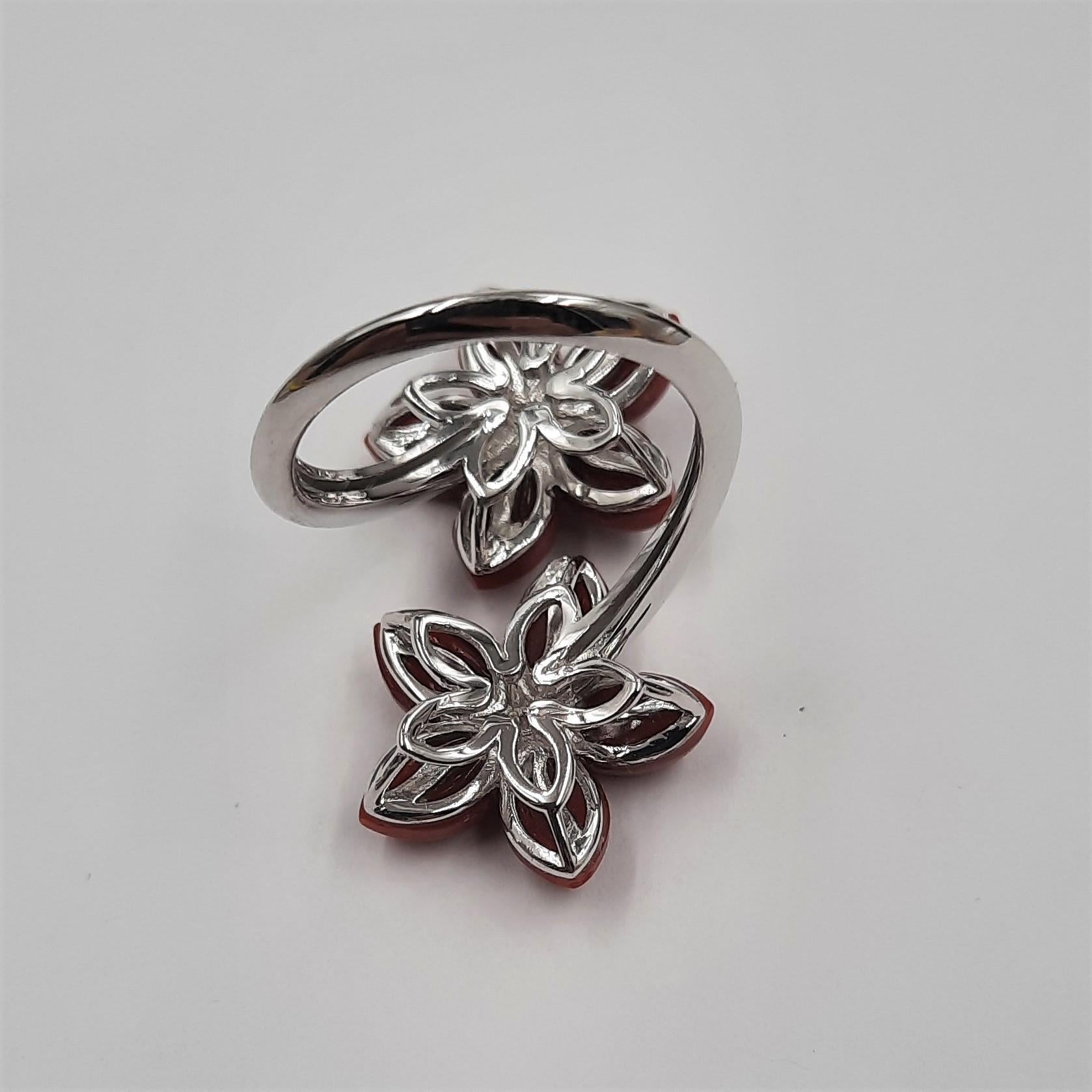 Pretty red natural coral (1.9 grams), brilliant cut diamond (0.09 carats) and 18 carats  white gold (5.8 grams) flower ring.  It is replicable, with coral of a different color (for example pink). See Listings. The ring are eventually part of a set,