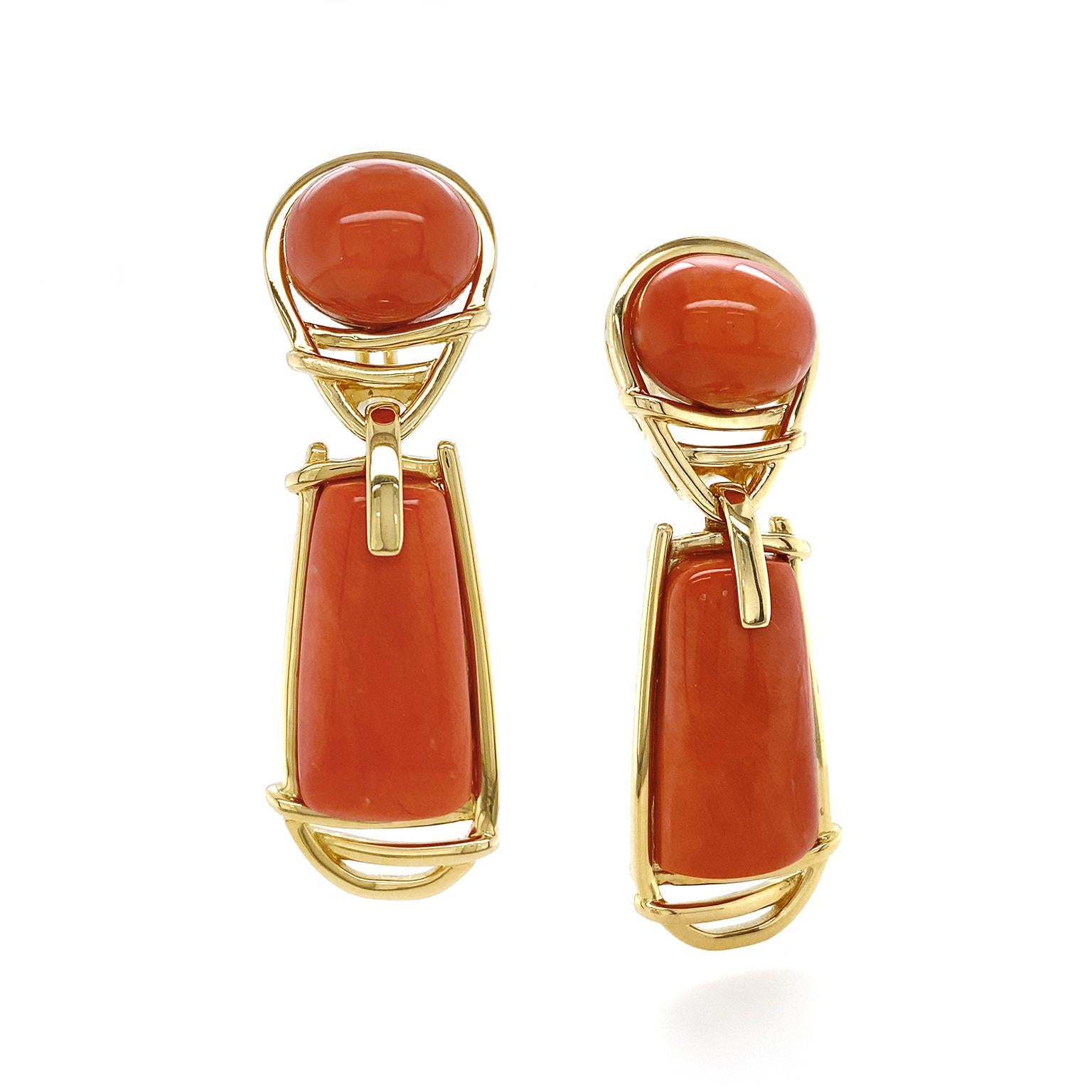 Blazing hue of red corals are emphasized by the equally vibrant 18k yellow gold. An oval cabochon of the gem begins the design, as gold traces around it to form an upturned teardrop. Next a gold link suspends an elongated trapezoid of red coral,