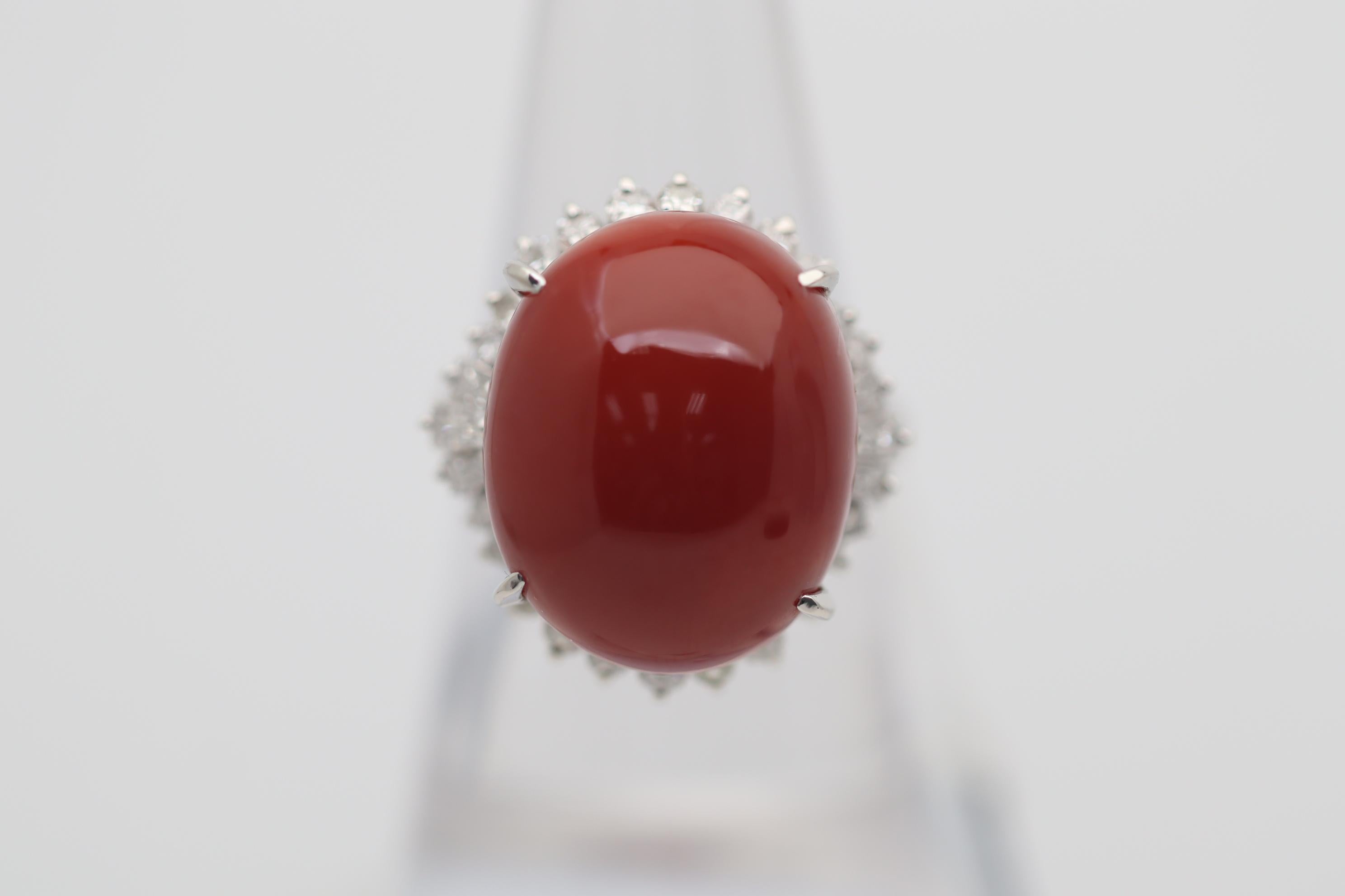 A large and impressive piece of natural red coral takes center stage! It measures 18.4mm x 14.9mm and has a bright polished rounded dome allowing the coral's natural deep rich red color showcase. It is complemented by 0.79 carats of round brilliant
