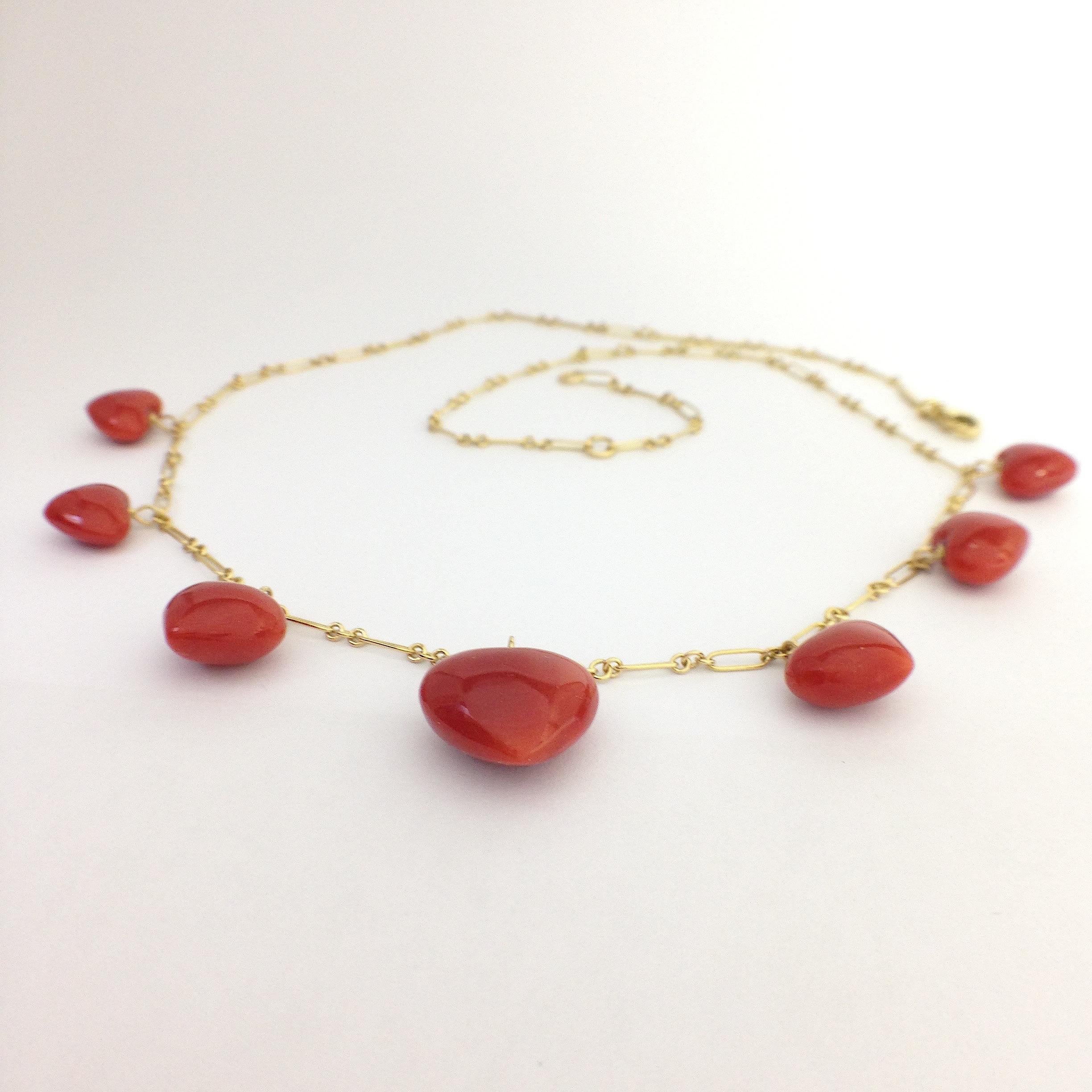 This is a necklace completely handmade in 18Kt gold.
It has 7 red coral hearts positioned from smaller to larger towards the center of the necklace.
It is 43 cm or 47 cm long because it has a ring at those two lengths.

We can make jewelry according