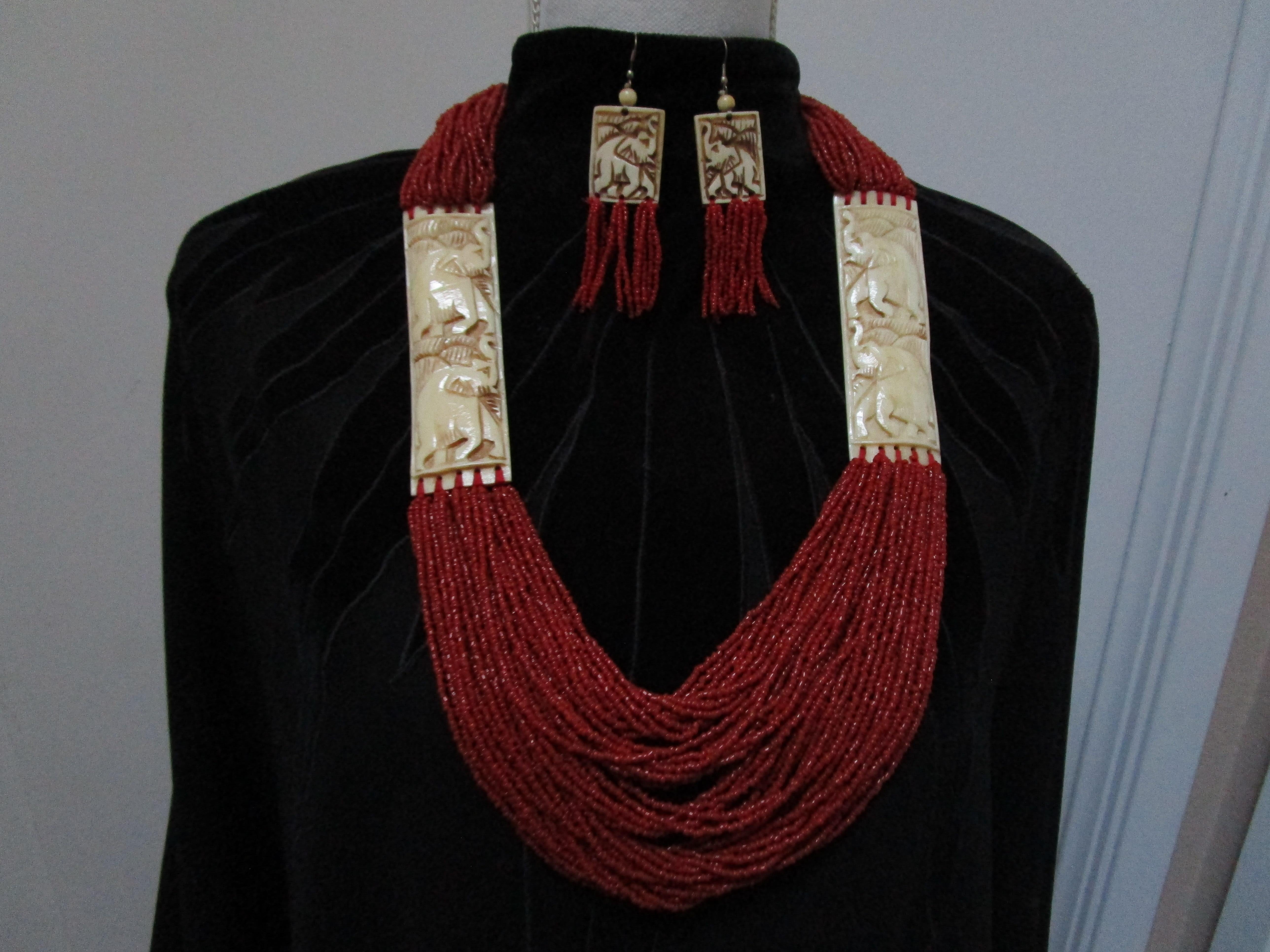 Each bead reflects light in this luminous multi-strand  red coral necklace with bone carving. It is modern and was acquired at an estate sale in Los Angeles. The long torsade necklace is composed of micro beads of coral, decorated with a pair of