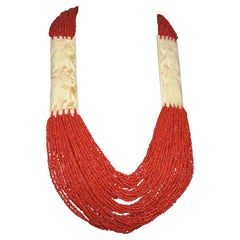 Collana e orecchini a più fili di corallo rosso con scultura in osso