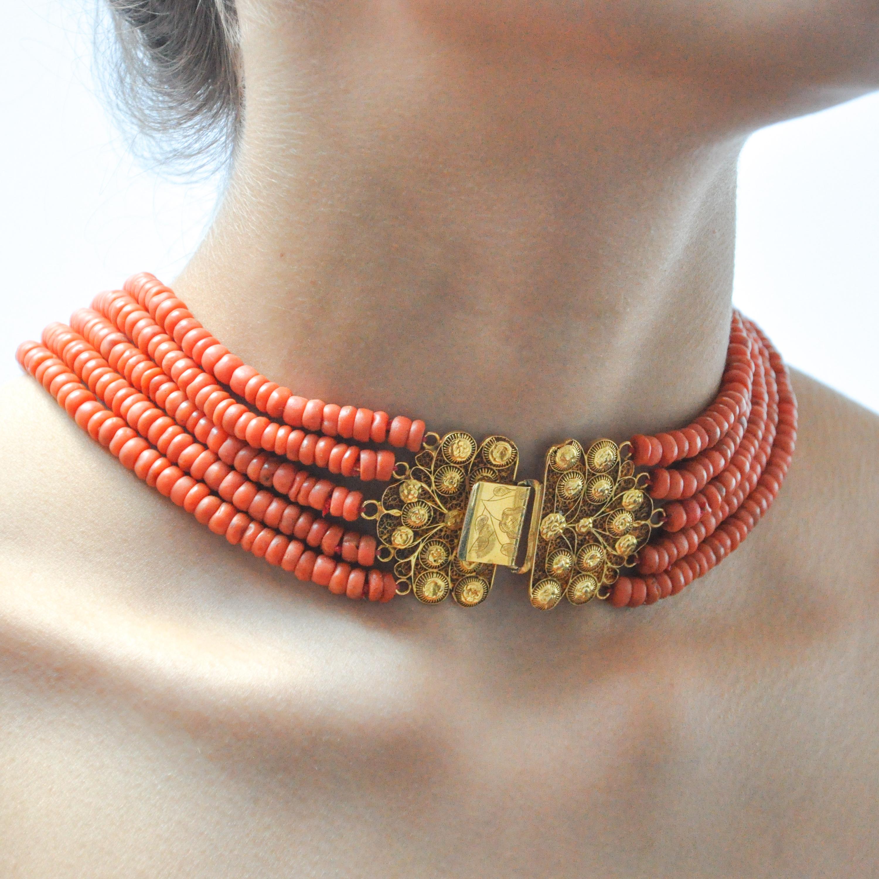 This antique 19th century red coral necklace is set with a large 18 karat gold clasp. The clasp is made of fine filigree and cannetille work, the craftsmanship is stunning. The closure of the clasp has a lovely floral engraving. The six strands are
