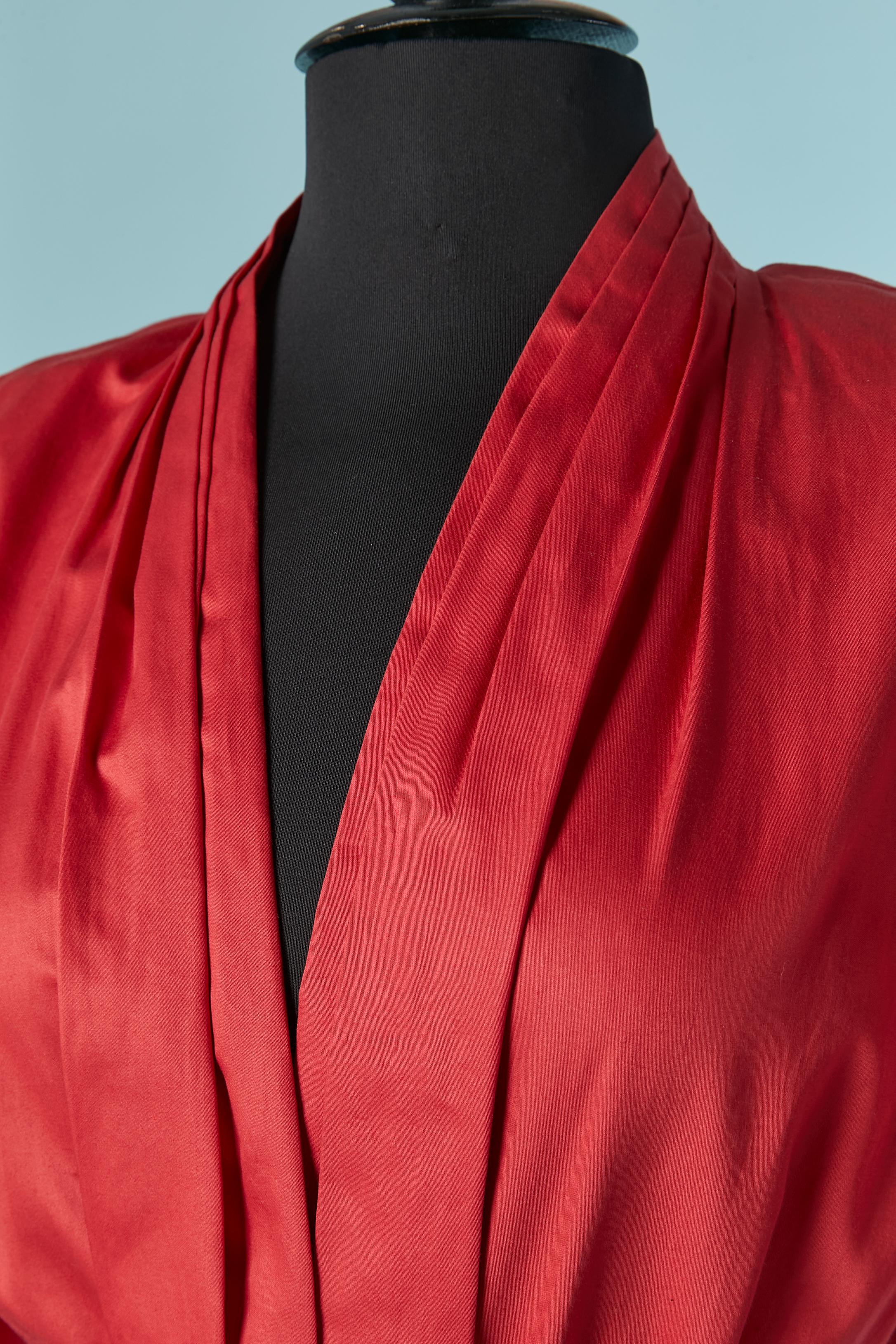 Rotes Baumwollkleid mit Gürtel . Tasche auf beiden Seiten. Verdeckter Druckknopf in der vorderen Mitte + einer am Ärmelrand Abgenähte Schulterpartie + Schulter-Pad. Falten in der vorderen Mitte und in der hinteren Mitte. In der Taille