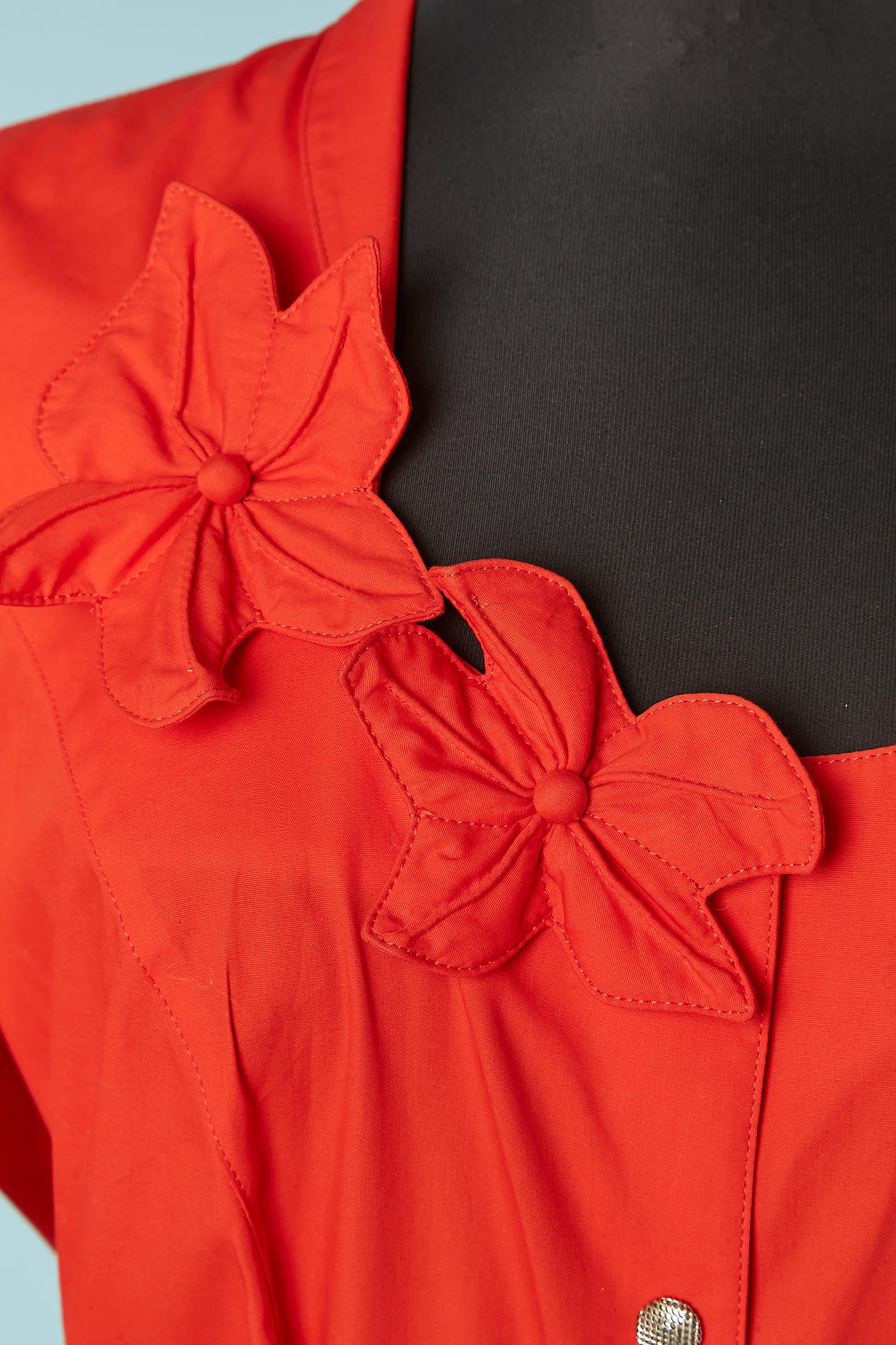 Robe en coton rouge avec application de fleurs en tissu rouge. Fermeture à bouton-pression sur le milieu du devant, poches sur les deux côtés. Découpage. 
TAILLE 40 (Fr) M 