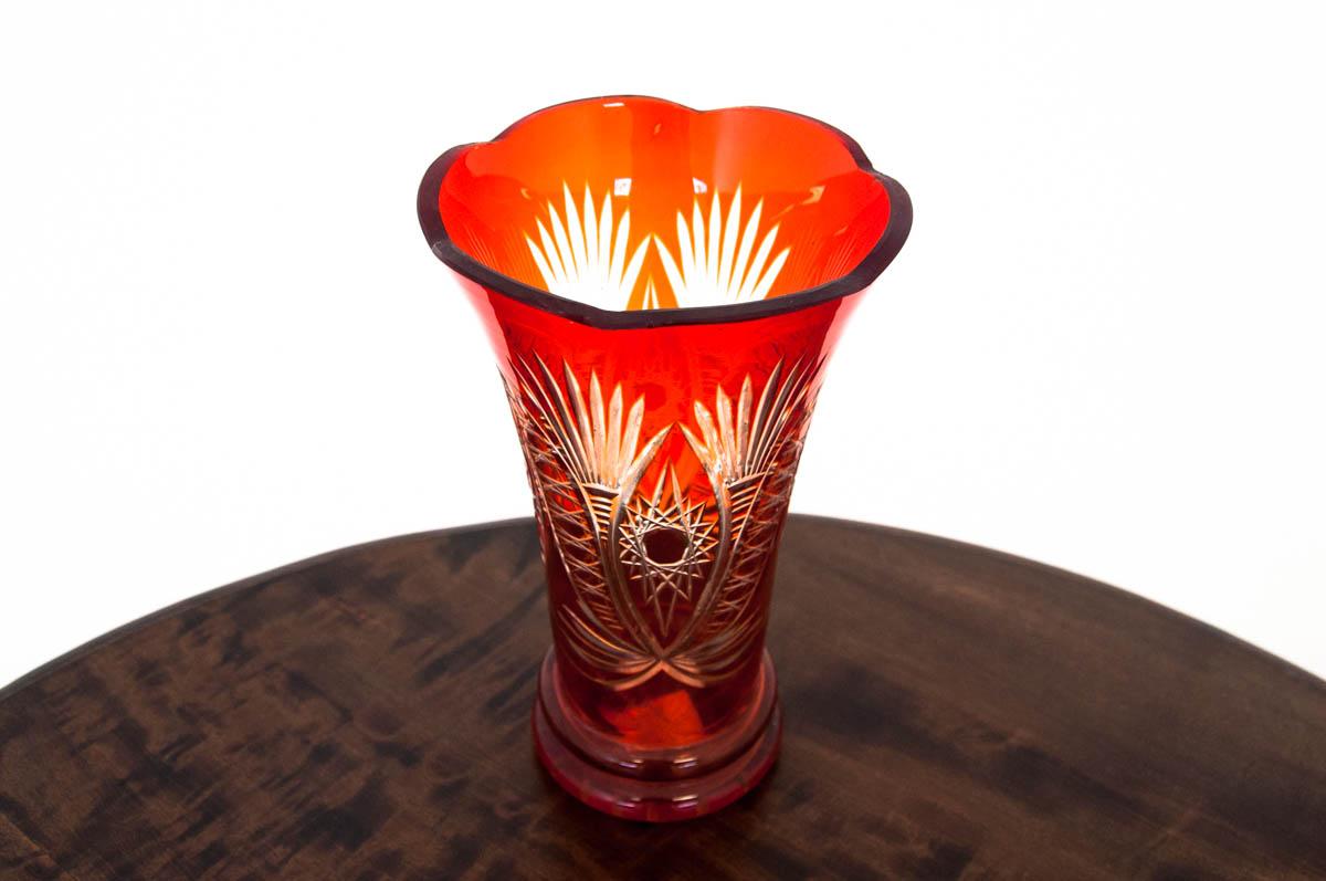 A carmine-colored crystal vase with polished patterns.

Made in Poland during the communist era.

Very good condition, no damage.

Dimensions: Height 25.5 cm / diameter at the outlet 14.5 cm.