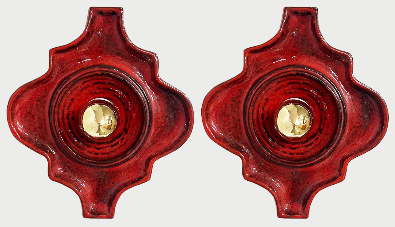 Curved red ceramic wall lights. Manufactured by Hustadt Leuchten, Germany in the 1970s.
We used gold light bulbs (see images), but silver light bulbs are also very stylish.

Measurements:
Width: 8.66 in (22 cm)
Heigth: 9.45 in (24 cm)
Depth: