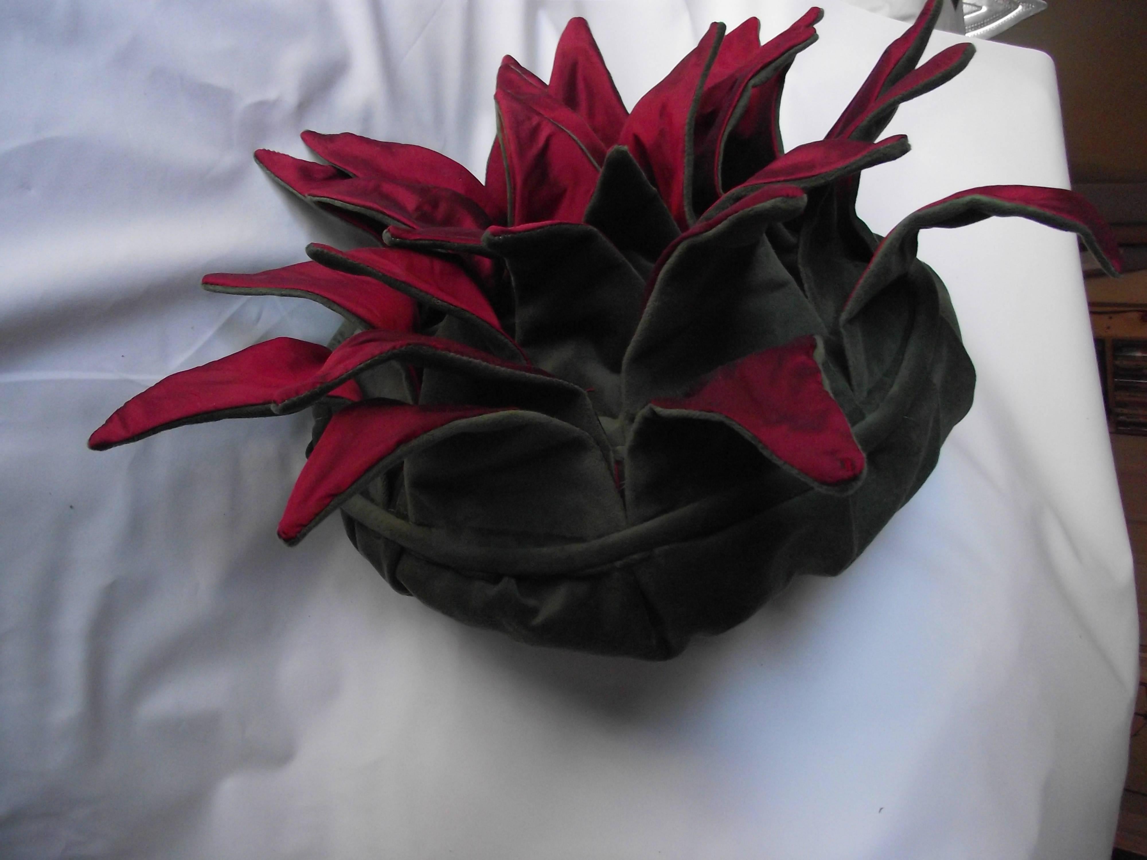This unusual throw pillow is another original design by W Gantt. It is produced entirely by hand in Gantt Design Studio.
Each red silk flower petal is wired to hold its shape and allow for reshaping. The center of each flower is embellished with