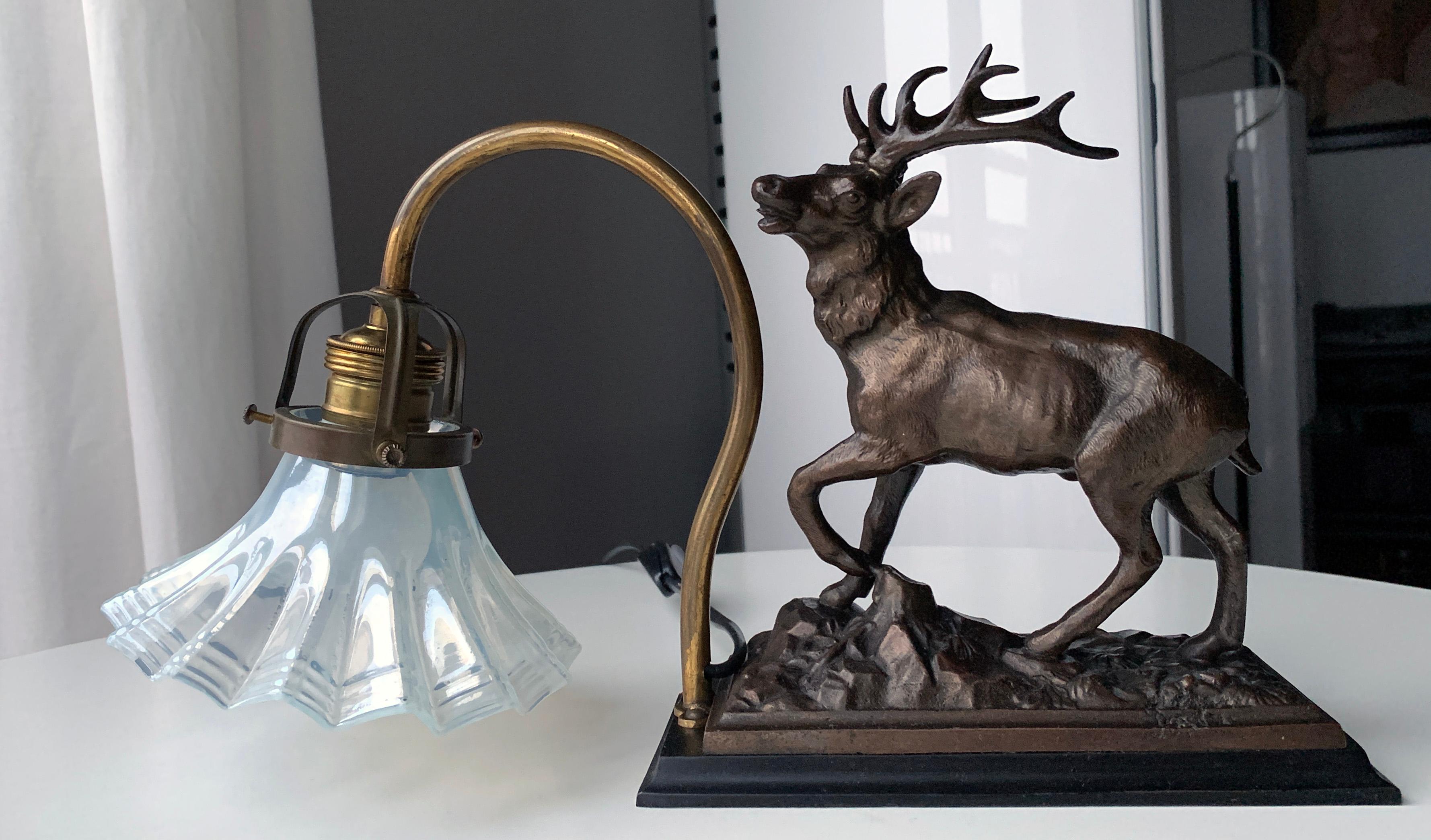 Danish red deer stag bookshelf lamp in Art Deco style. Sculptured bronze patinated zinc Red Deer Stag mounted on black metal plinth. Brass tubular arm with glass holder. Sculptural semi transparent glass shade with a milky appearance. New black