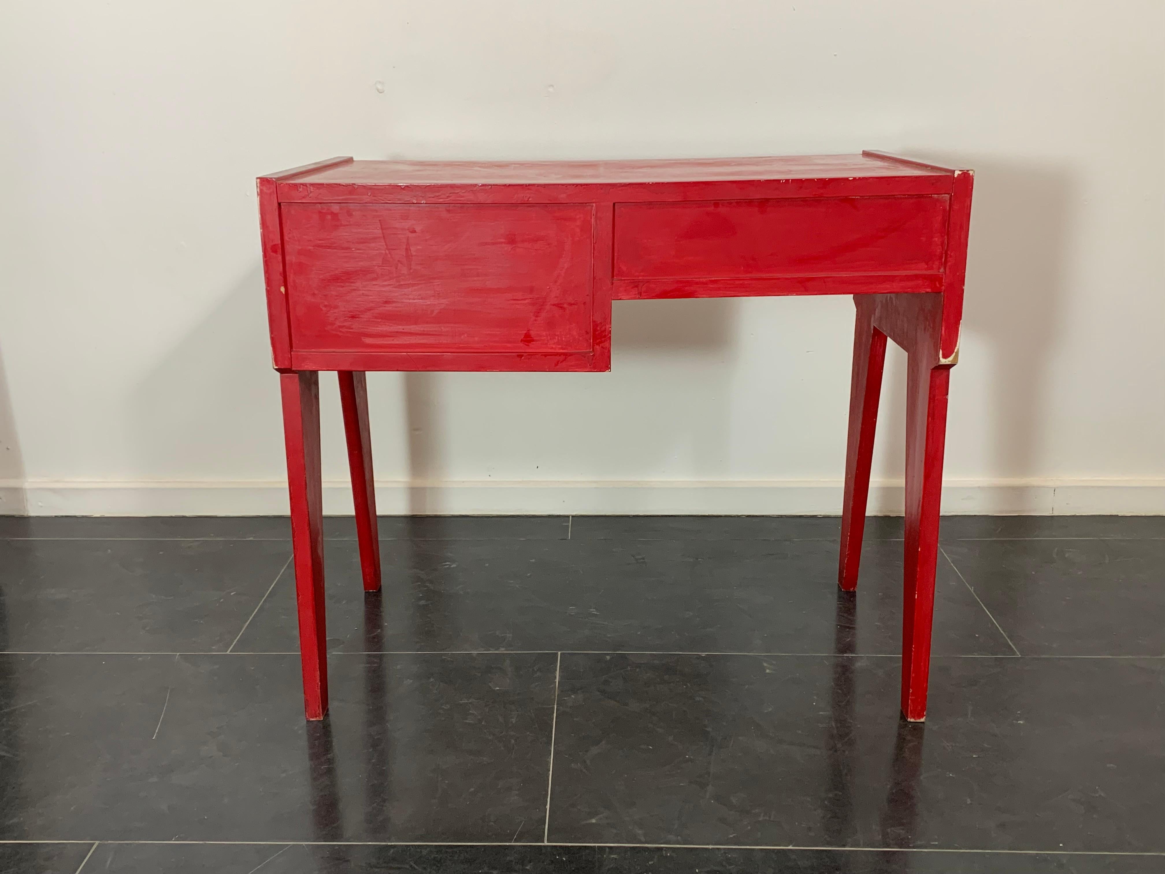 Bureau laqué rouge sur préparation de colle et de plâtre, années 1950. Equipé d'un tiroir et d'un compartiment ouvert. Retouchée et repeinte ultérieurement. Il présente une patine due à l'âge et à l'utilisation, aux retouches et à la peinture