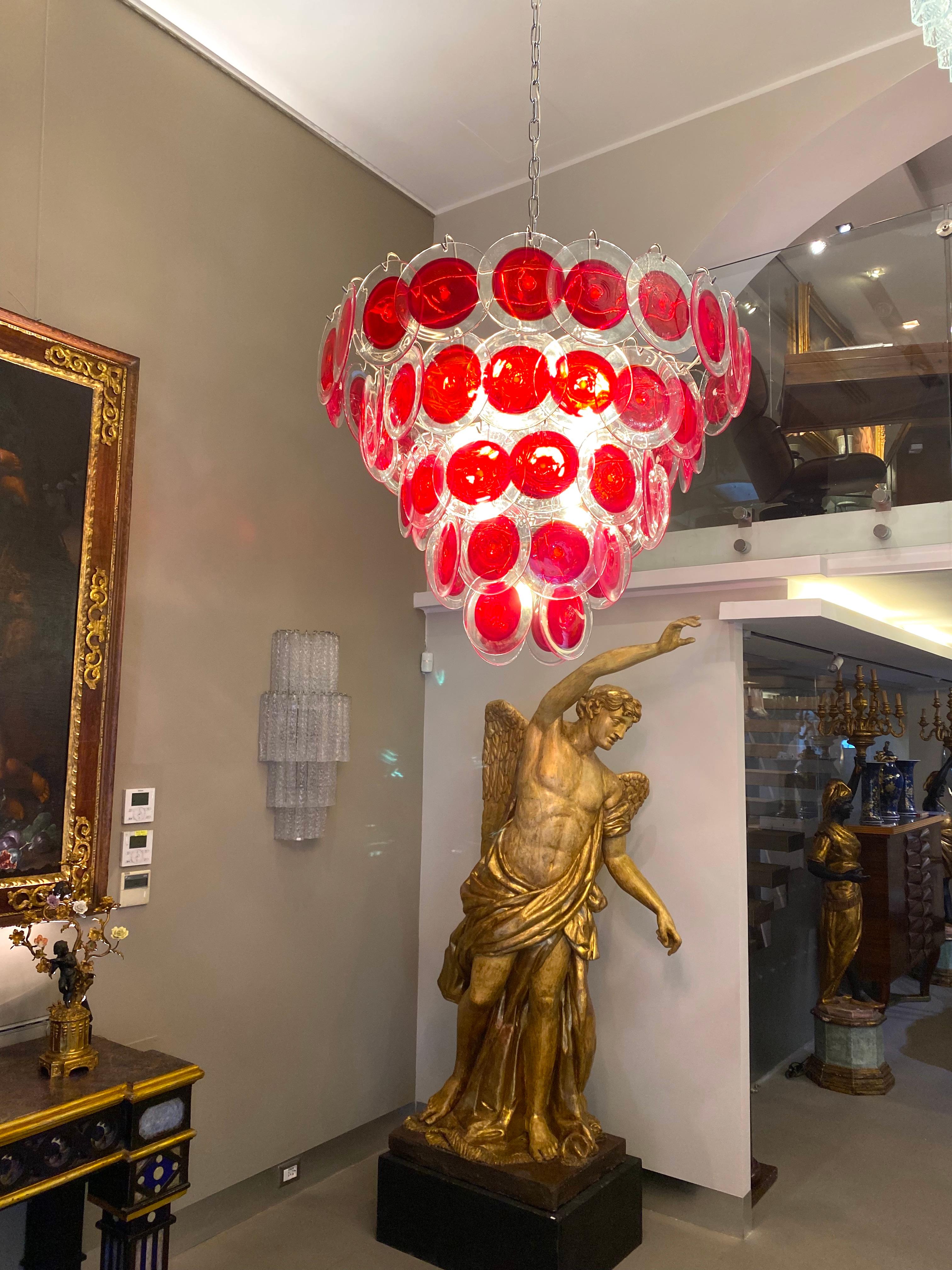 Lustre à disque en verre rouge de Murano de forme ronde. 
Chaque lustre est composé de 50 disques rouges en verre précieux de Murano et disposé sur cinq niveaux.
La personnalisation est possible dans différentes tailles, finitions et couleurs de