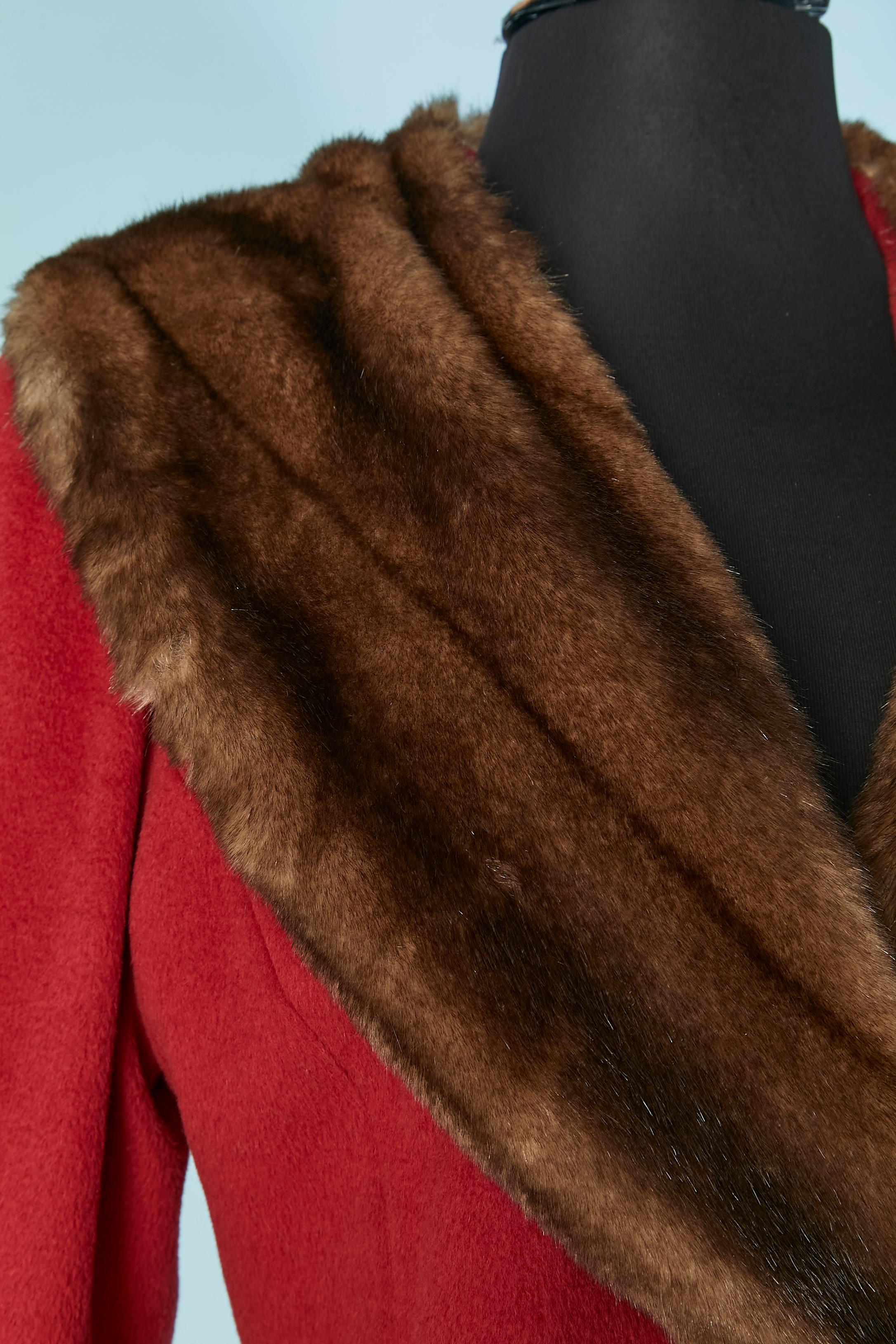 Red double breasted coat with faux fur collar. Fabric composition: 50% wool, 40% angora, 10% cashmere. Lining is probably made of rayon. 
Leather button and buttonhole closure on the middle front. Half-belt on the back with 4 leather buttons. Pocket