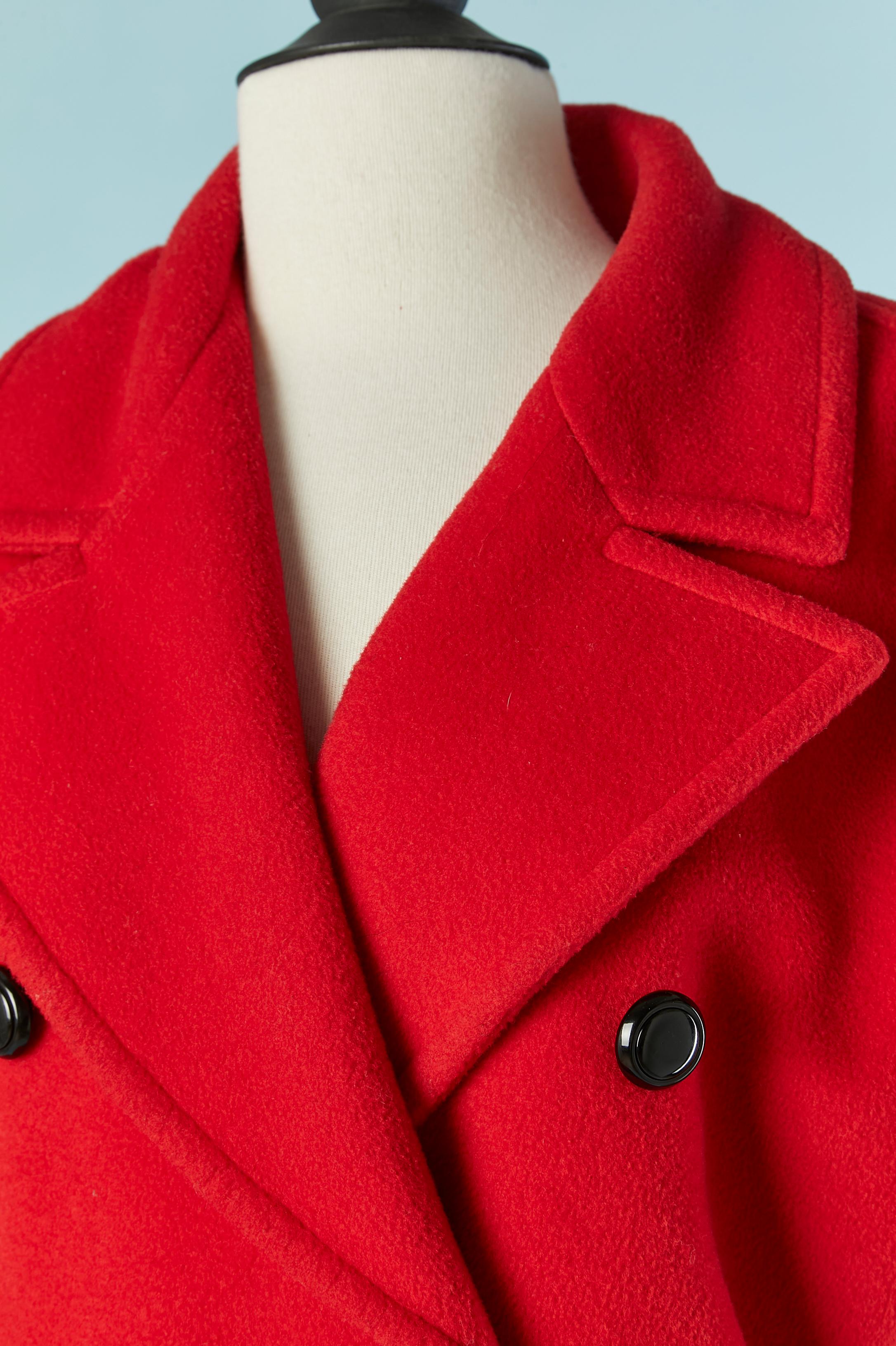 Red double breasted wool coat. No fabric composition tag but the lining is probably rayon. Raglan sleeve. Button and buttonhole closure on the front. Pocket flap ( but no pocket, only the flap) Gather around the waist. Gros-grain edge at the end of