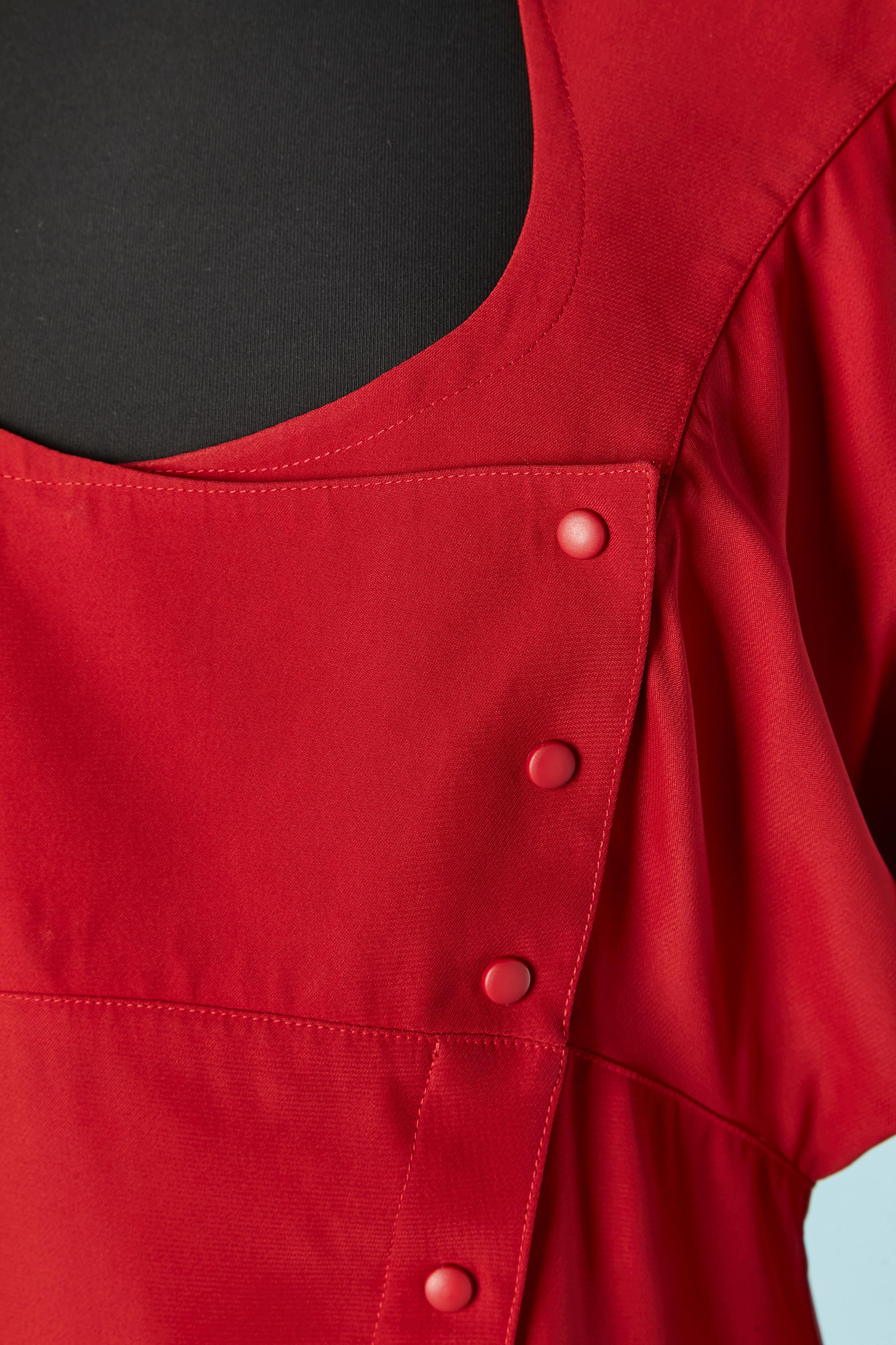 Robe rouge avec découpes. Composition du tissu : 55% acétate, 45% rayonne. 
Fermeture par boutons-pression au milieu du devant et aux poignets. Grand pad sur l'épaule, une poche sur le côté droit.
TAILLE 40 (Fr) M 