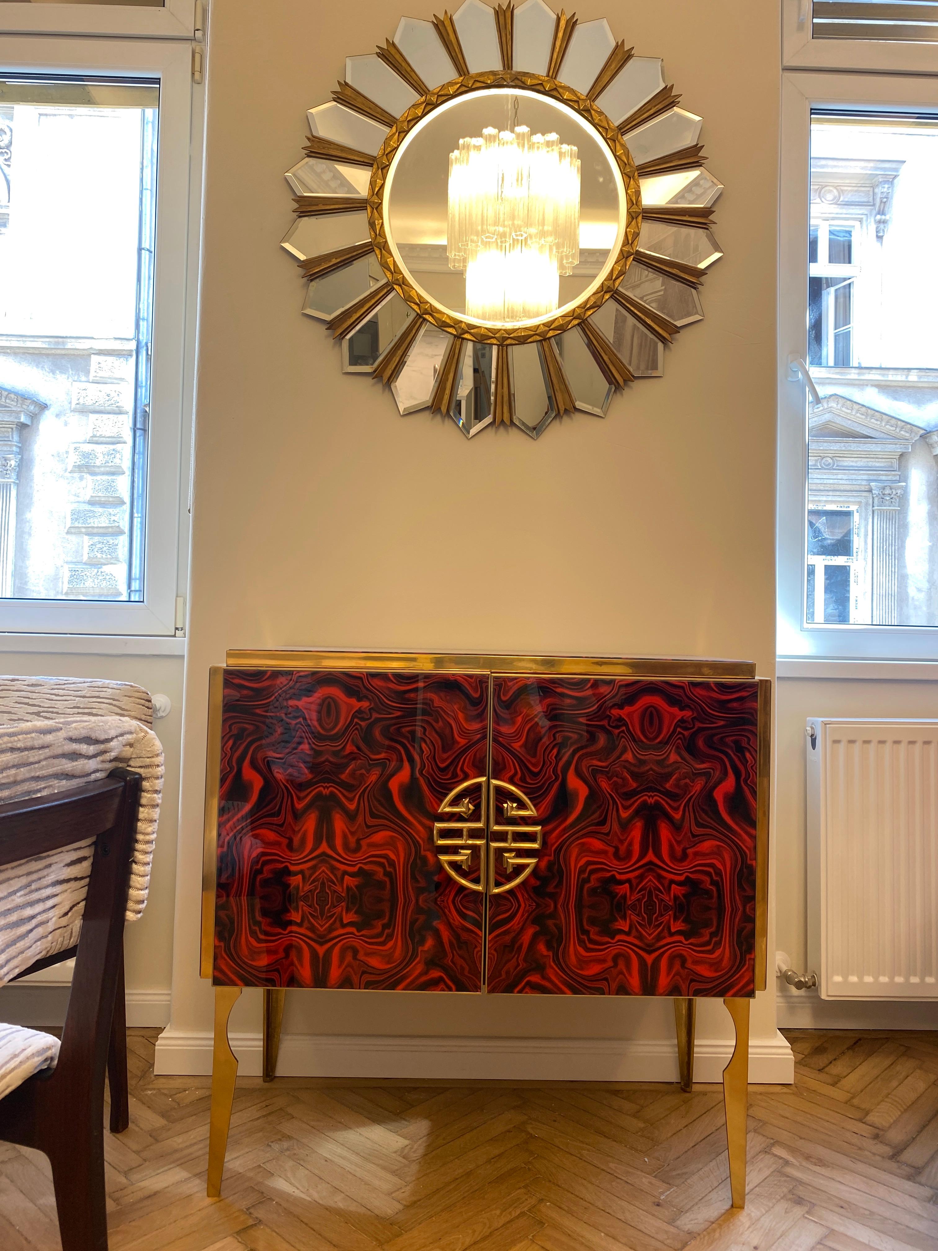 Un raffinato mobile bar realizzato a mano da un maestro artigiano. Cornice in ottone con fantasia di fiori rossi rubino tagliati a mano e realizzati a mano  Vetro di Murano, sollevato su speciali gambe in ottone.
