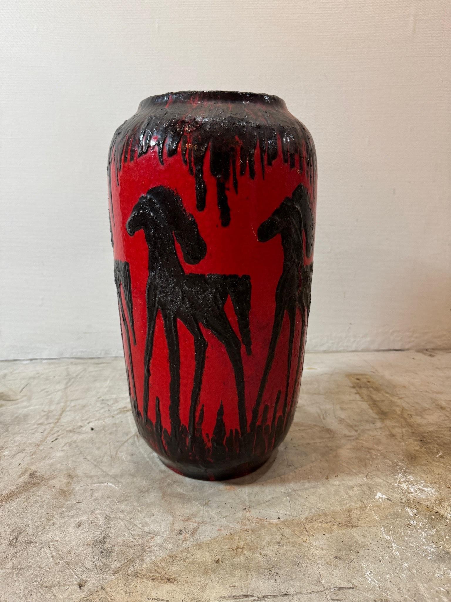 Realizzato da Scheurich nella Germania occidentale, la sua audace tonalità rossa si integra con i sorprendenti motivi equini in marrone scuro e nero. Adornato con dettagli in rilievo, questo capolavoro vintage vanta un interno accattivante in uno