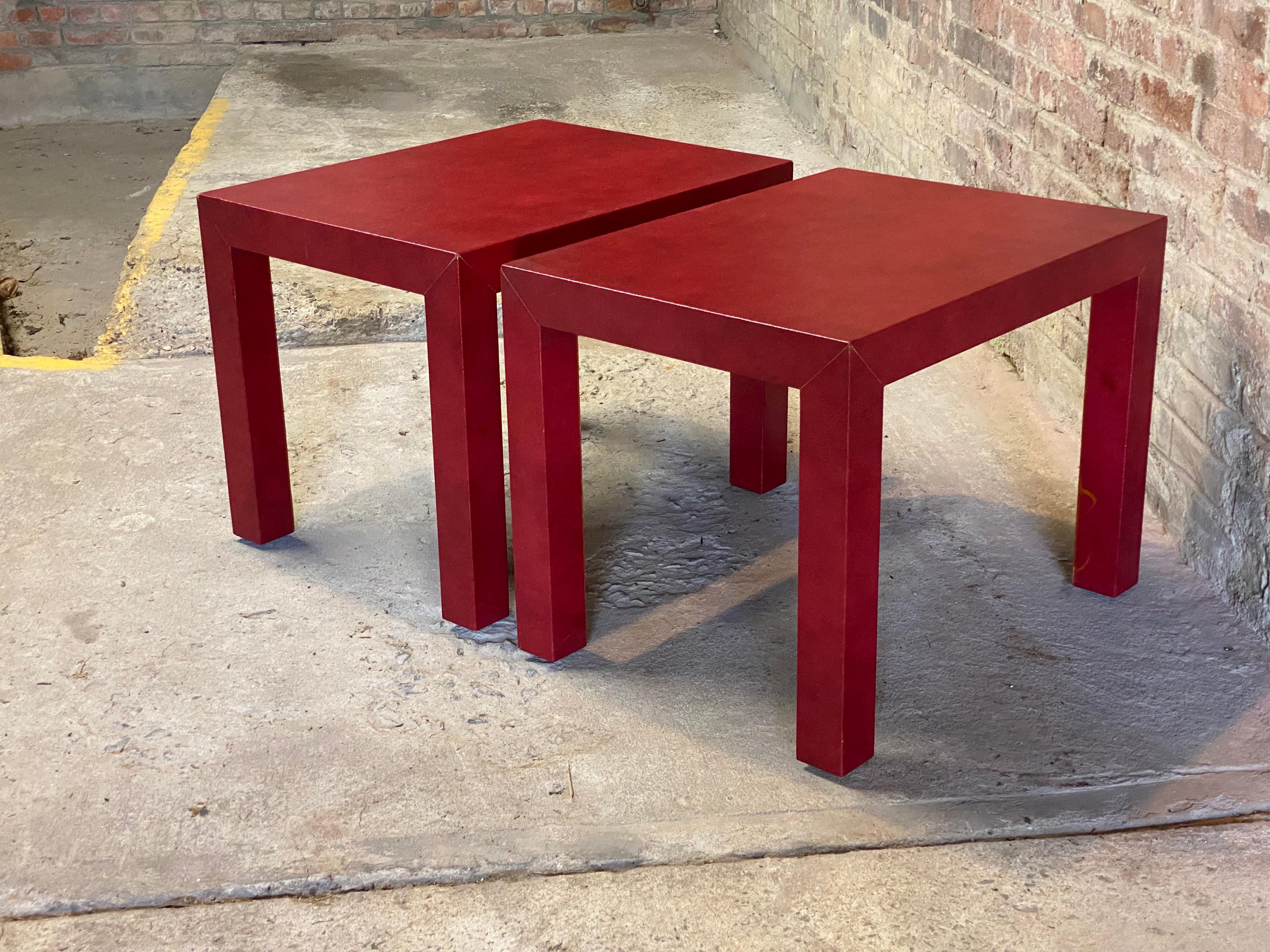 A fine pair or red faux lizard skin clad Parsons style end tables. Circa 1980. Give your room a shot of color and flare with these classic tables. Legs are flush with the top and equal to its thickness. The Parsons table was a concept and design