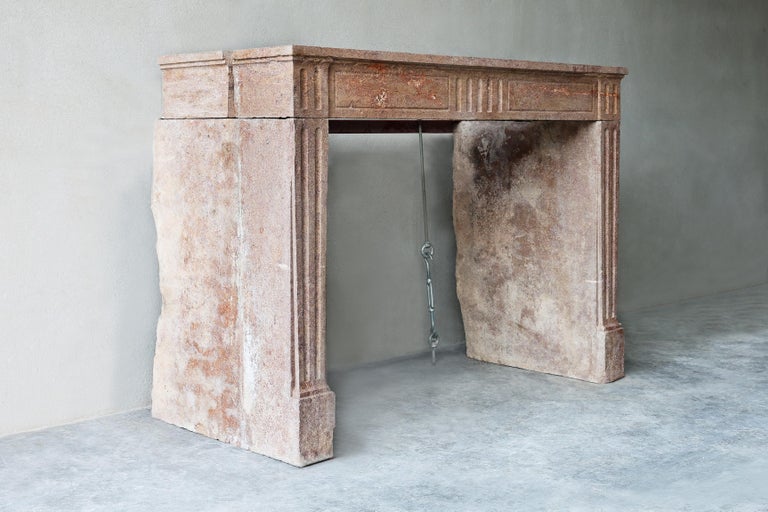 Beautiful red fireplace of marble stone from the 19th century in the style of Louis XVI. This antique fireplace has flutes in the front part and on the legs! A beautiful sleek fireplace with straight legs and shapes.