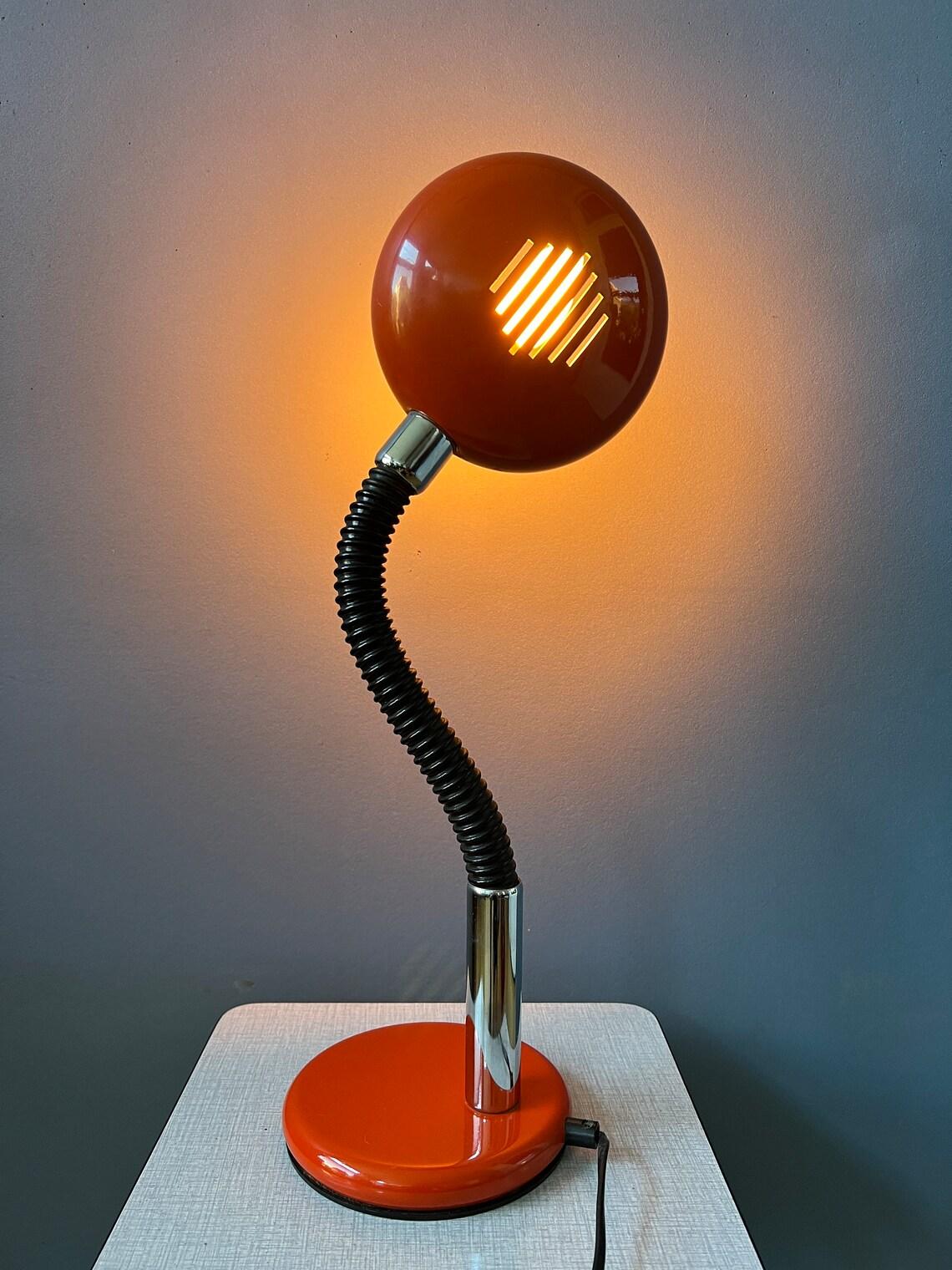 Red space age table lamp with flexible arm. The arm and shade can be positioned in any way desirable, see pictures. Also the shade itself be repositioned. The lamp requires one E27/26 (standard) lightbulb and currently has an EU plug.

Additional