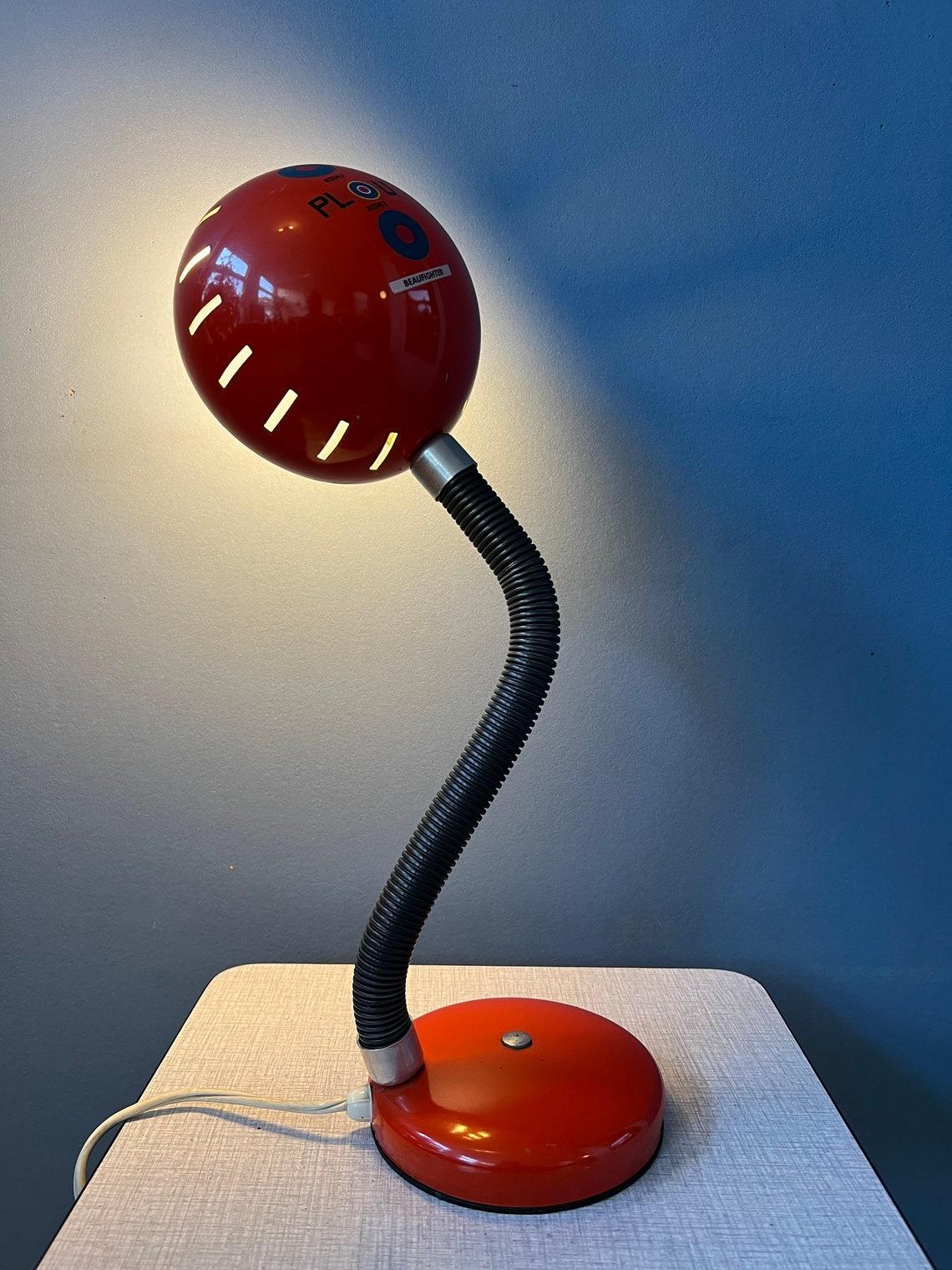 Red vintage table lamp with flexible arm. The arm and shade can be positioned in any way desirable, see pictures. The lamp is made out of metal and black tube is plastic. The lamp requires one E27/26 (standard) lightbulb and currently has an EU