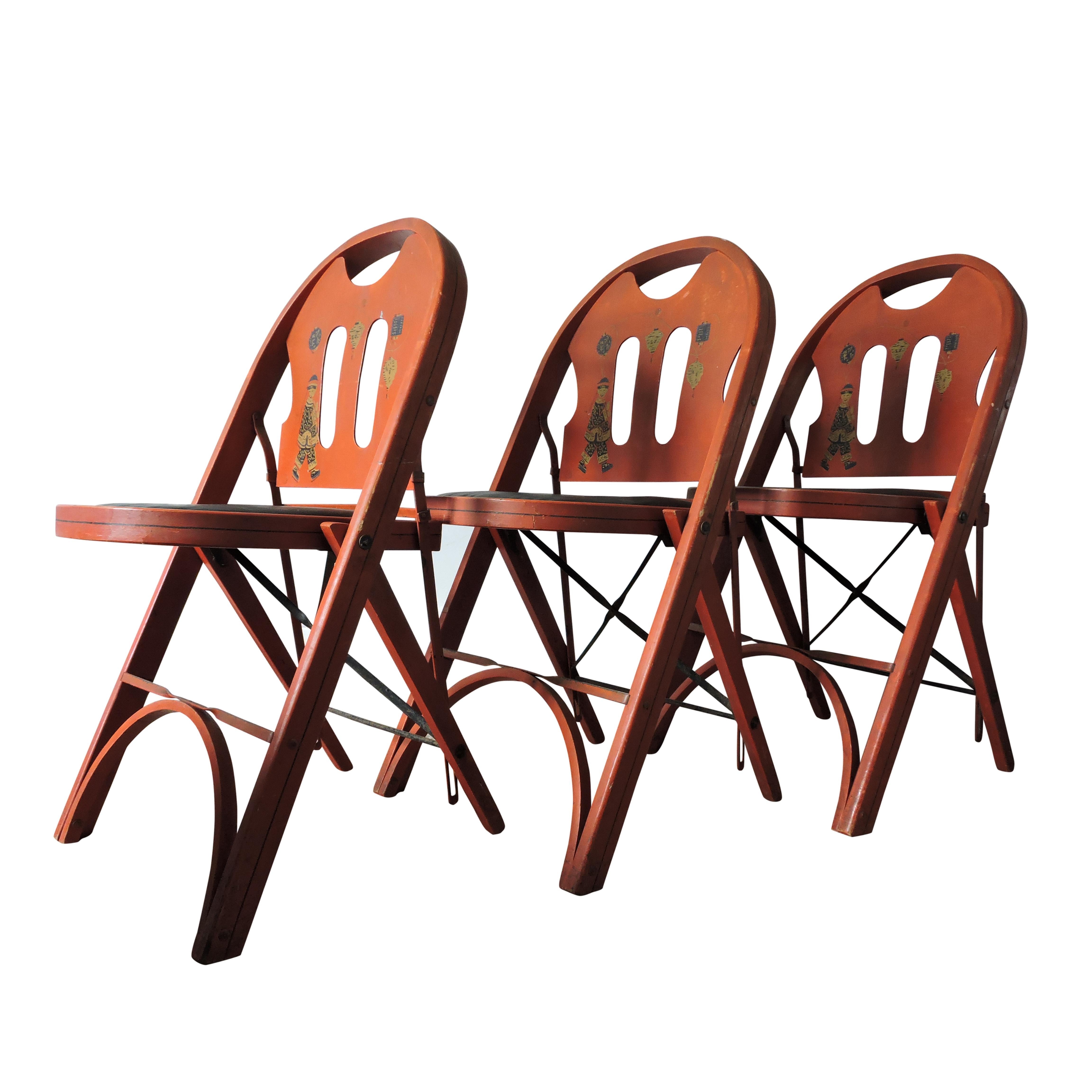 Vintage furniture set of three chairs. Painted red wood chairs and table with oriental figural motif on the backrests. Maker's Label reads: Louis Rastetter & Sons, The Solid Kumfort, Fort Wayne, Ind. USA, circa 1920s.

 