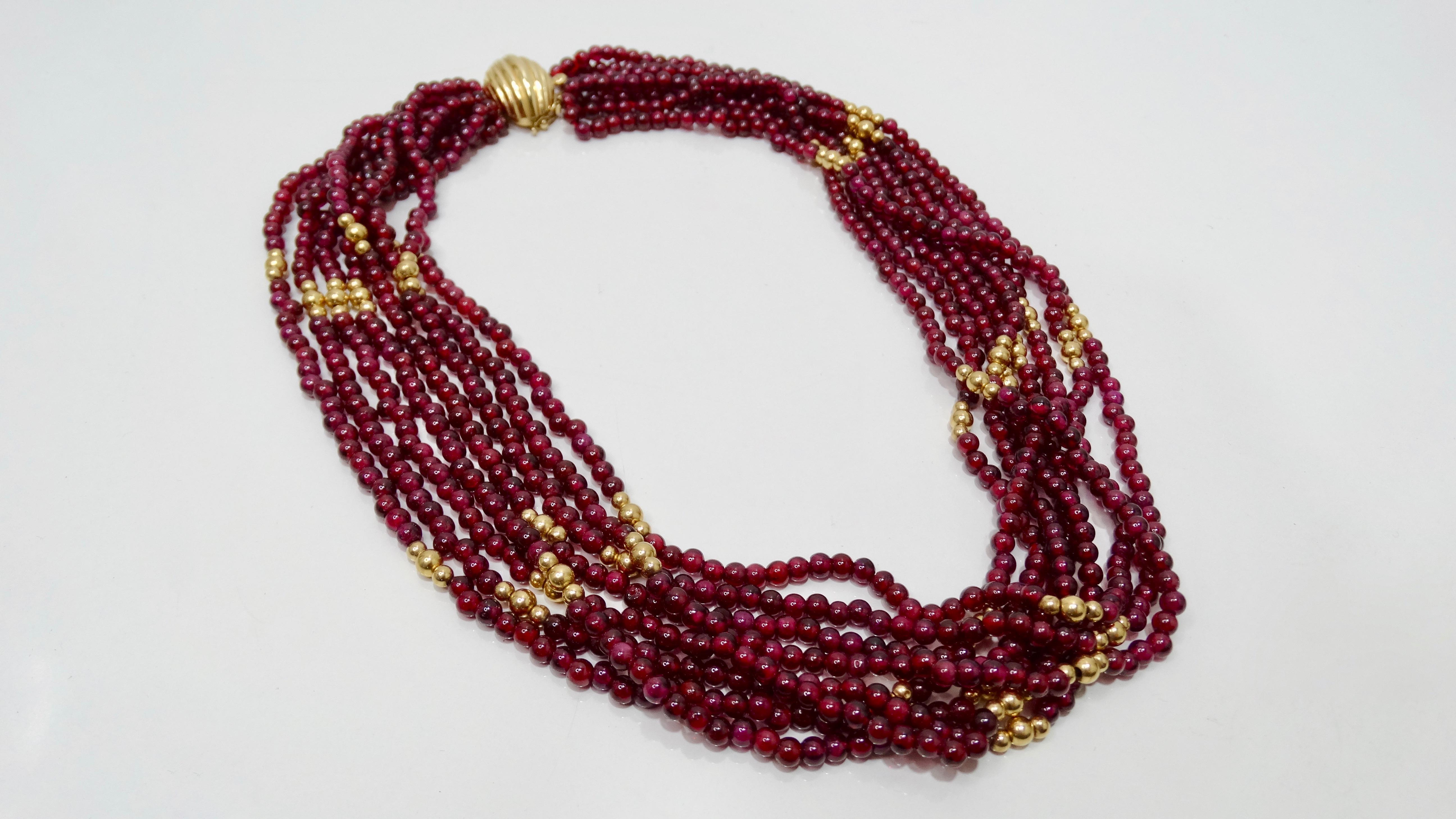 Ergänzen Sie Ihre Sammlung mit dieser atemberaubenden Halskette aus Granat und Gold! Dieses mehrreihige Collier aus der Mitte des 20. Jahrhunderts besteht aus 8 Perlenreihen mit etwa 300 rubinroten Granaten und 14-karätigem Gold. Sie hat einen