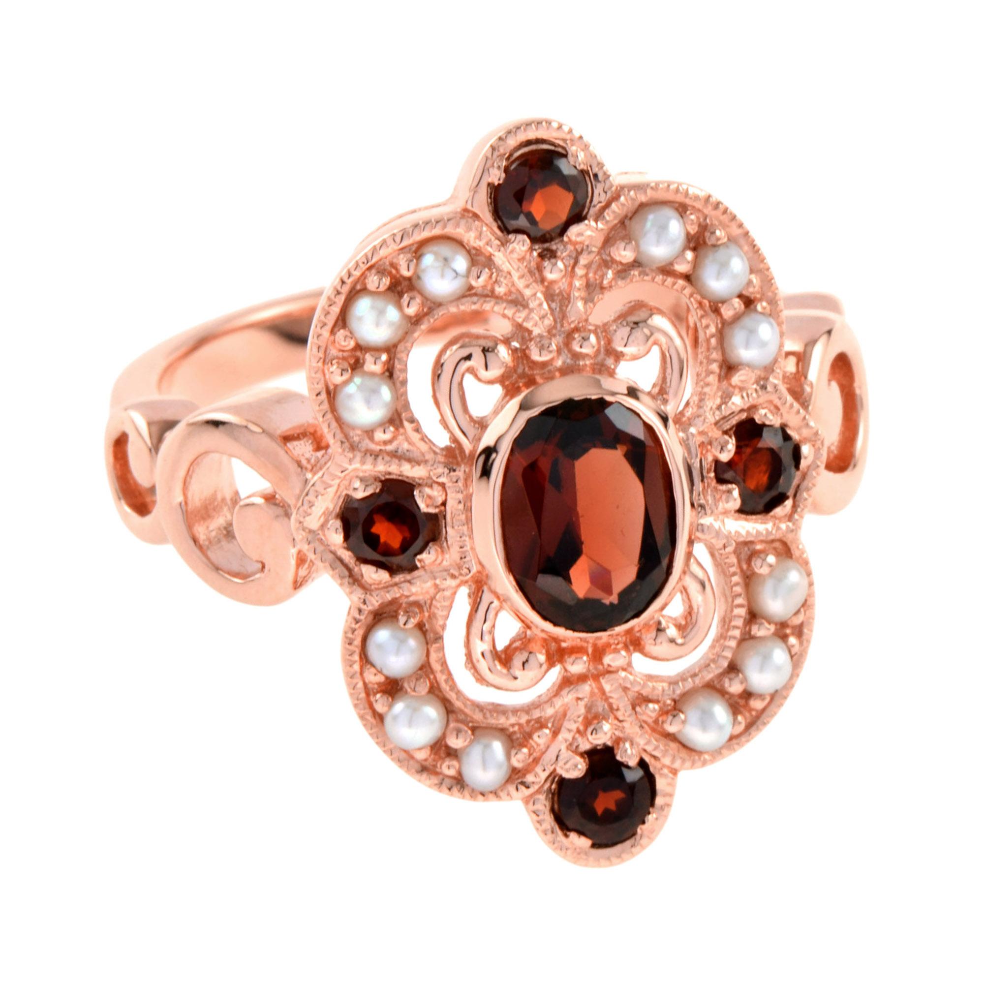 Un anillo de cóctel muy encantador con un granate central ovalado de 7×5 mm. flanqueado por otros cuatro granates y perlas. El engaste del anillo está bien hecho en oro rosa de 14 quilates con detalle de borde milgrain. Este maravilloso anillo de