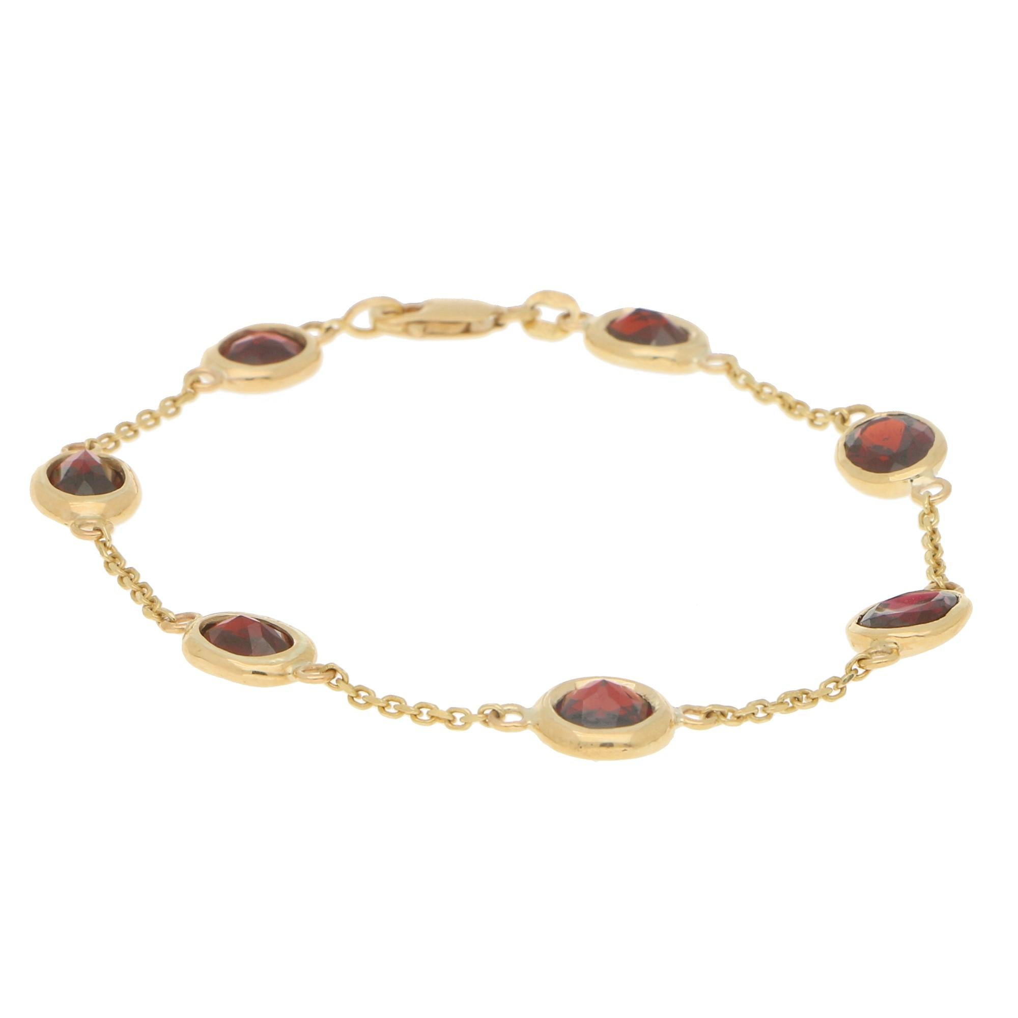 A beautiful red garnet spectacle bracelet set in 9k yellow gold. The piece is composed of 7 unique garnets all varying in size and cut. Each stone is rub over set in yellow gold which allows the wearer to fully appreciate each garnet from both