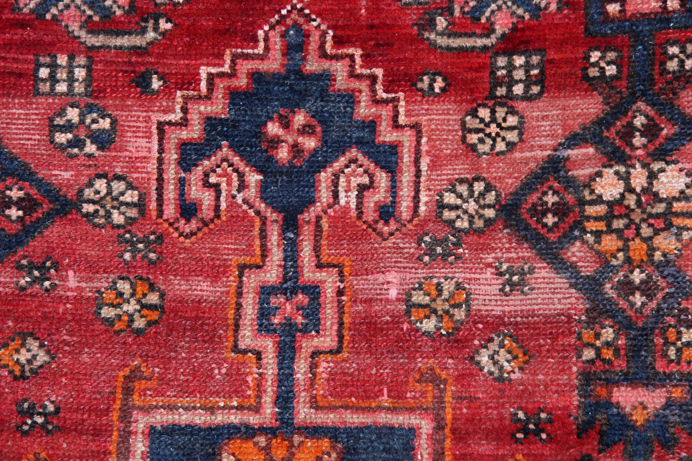 This is a prime example of vintage carpets, handwoven in the 1960s. Both the colour, design and construction of this fine wool rug make it the perfect accent piece. Woven with a rich red background with a fantastic tribal design, symmetrically woven