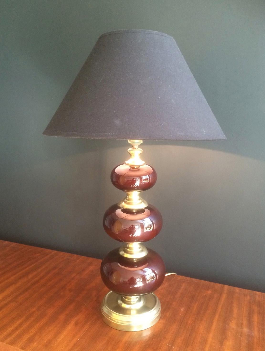 This beautiful table lamp is made of 3 nice red glass balls and brass elements. This is a nice work by a French designer, circa 1960.