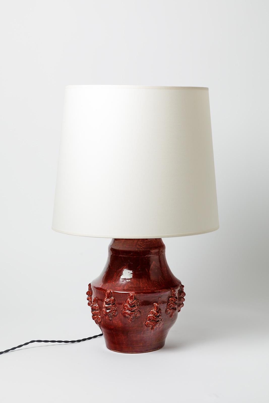 Red glazed ceramic lamp by Jean Austruy.
Artist signature under the base « J. Austruy ». Circa 1960-1970. 
H : 8.2 x 8.2 inches (ceramic only).
H : 13.4 x 8.2 inches (ceramic and electrical system).
H : 21.6 x 13.7 inches (ceramic, electrical system
