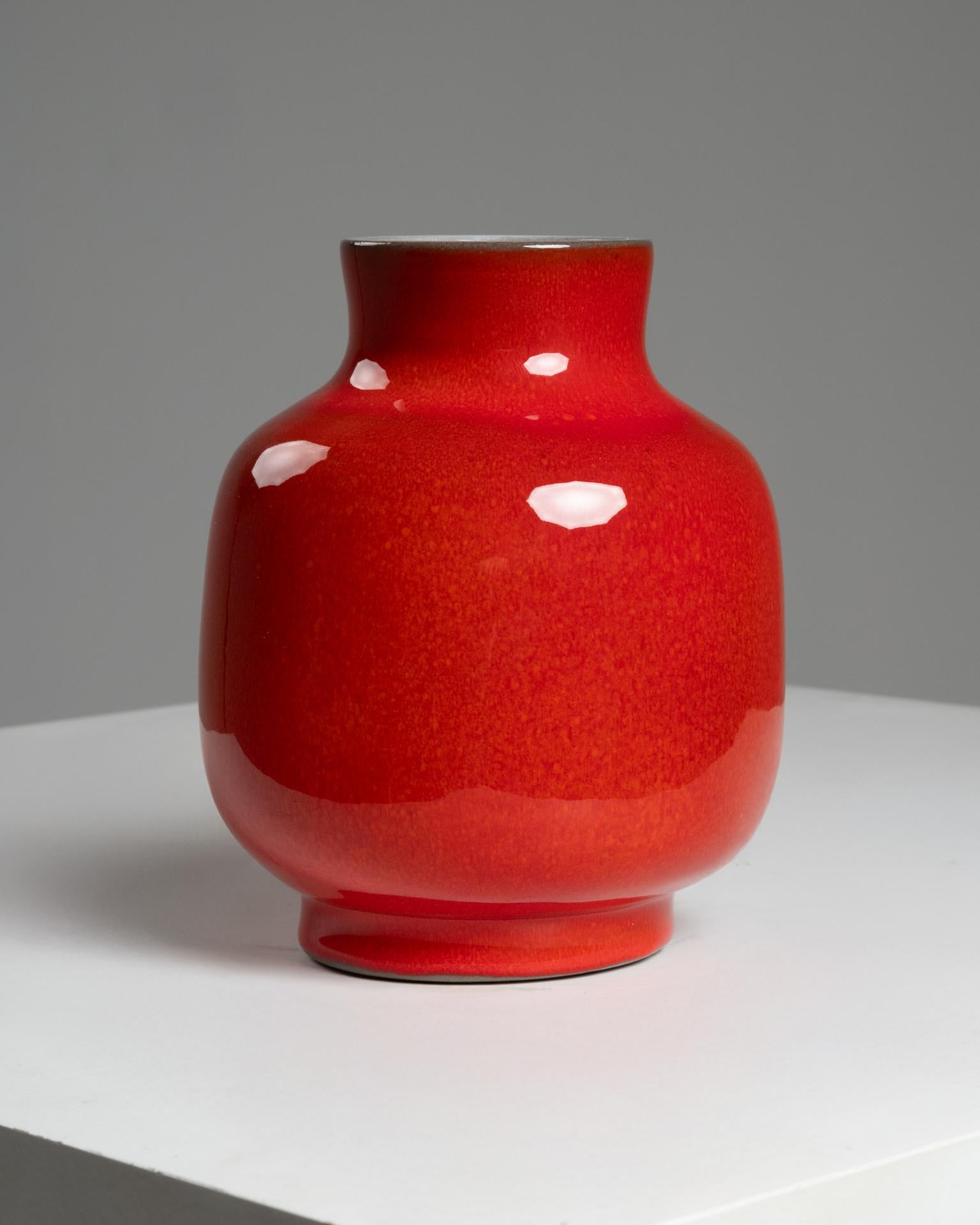 Este vibrante jarrón de cerámica esmaltada roja fue obra de los famosos ceramistas franceses Jacques (1926-2008) y Dani (1933-2010) Ruelland, cuyo trabajo en colaboración definió una estética única en las artes decorativas francesas de posguerra.