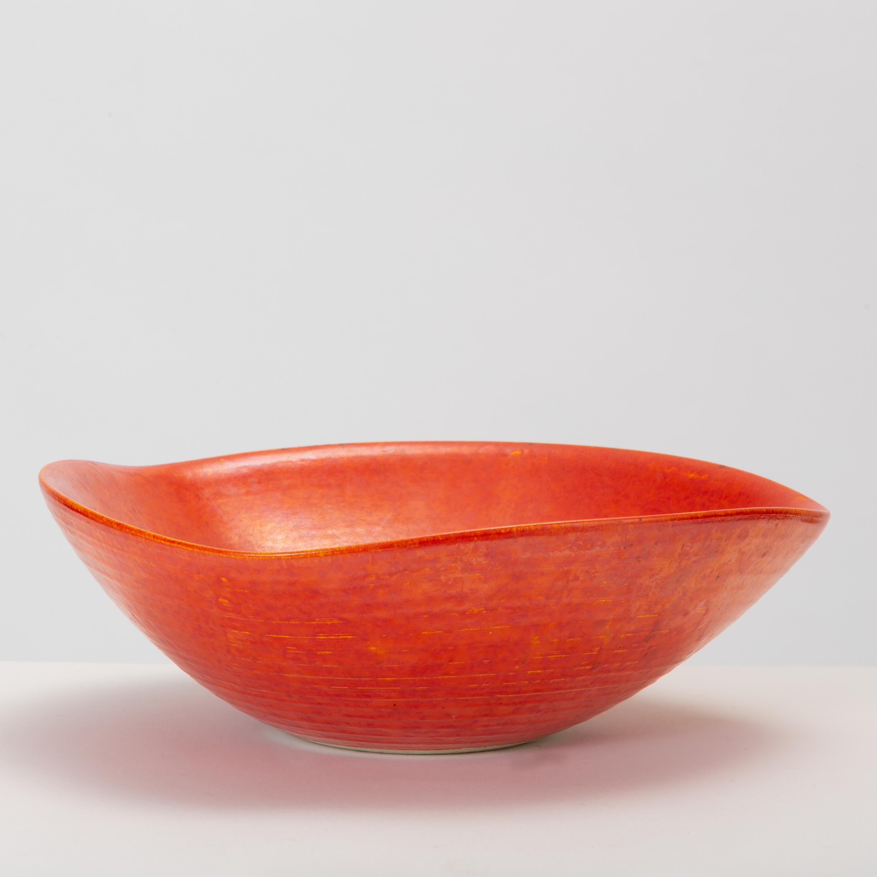 A tomato red studio pottery bowl from California with an irregular shape, ribbed texture, and a slightly iridescent glaze. Signed on bottom of bowl “1968 Oakland Rev. Y Tsugiyama.”

Condition: Excellent vintage condition with no chips or