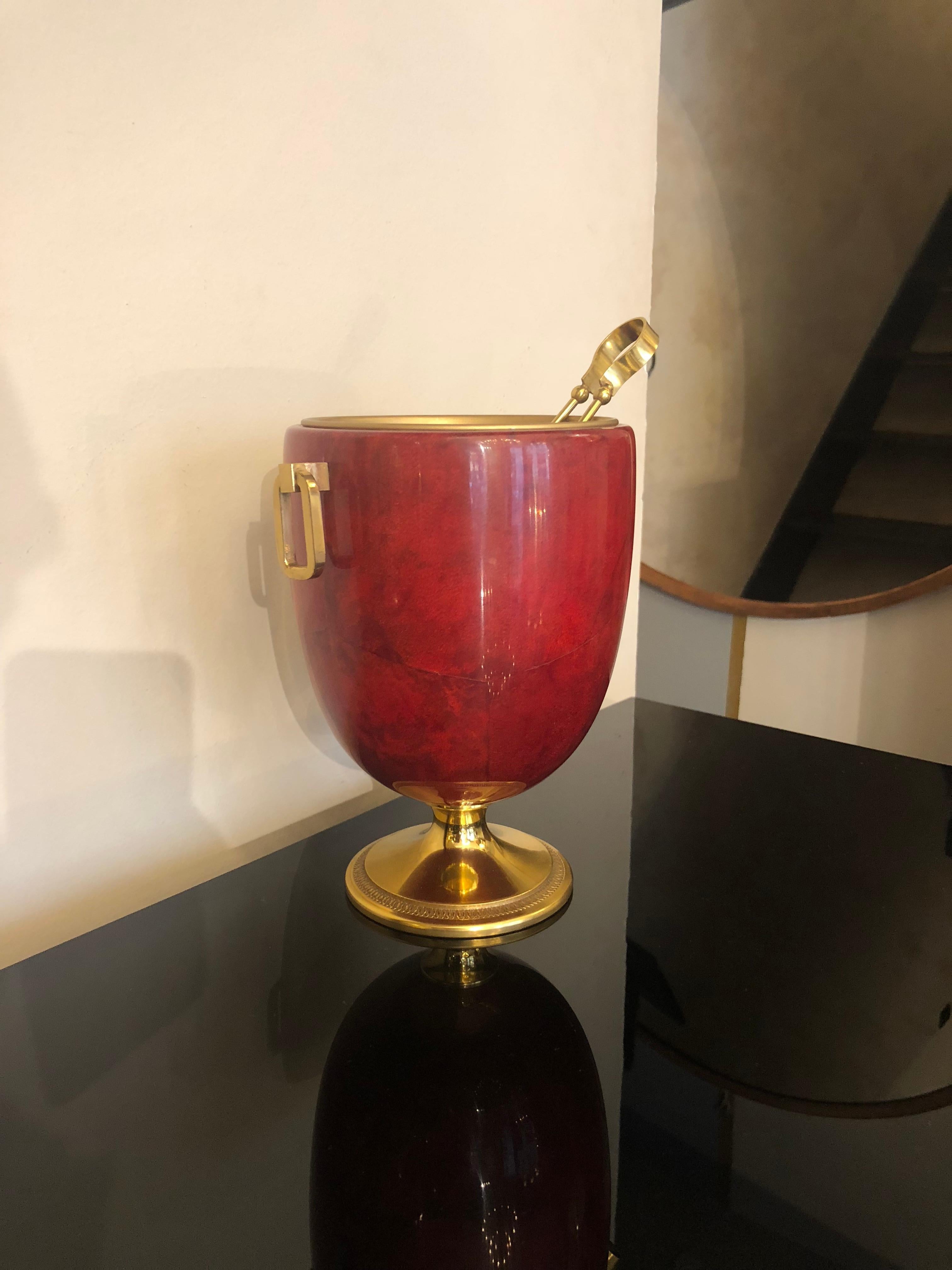 Wooden red goatskin ice bucket attributed to Aldo Tura, made in Italy, circa 1970s. A golden metal cup is the protection for the wooden bucket which is covered with goatskin and it is the place where to put the ice. Tongs are present to help you to