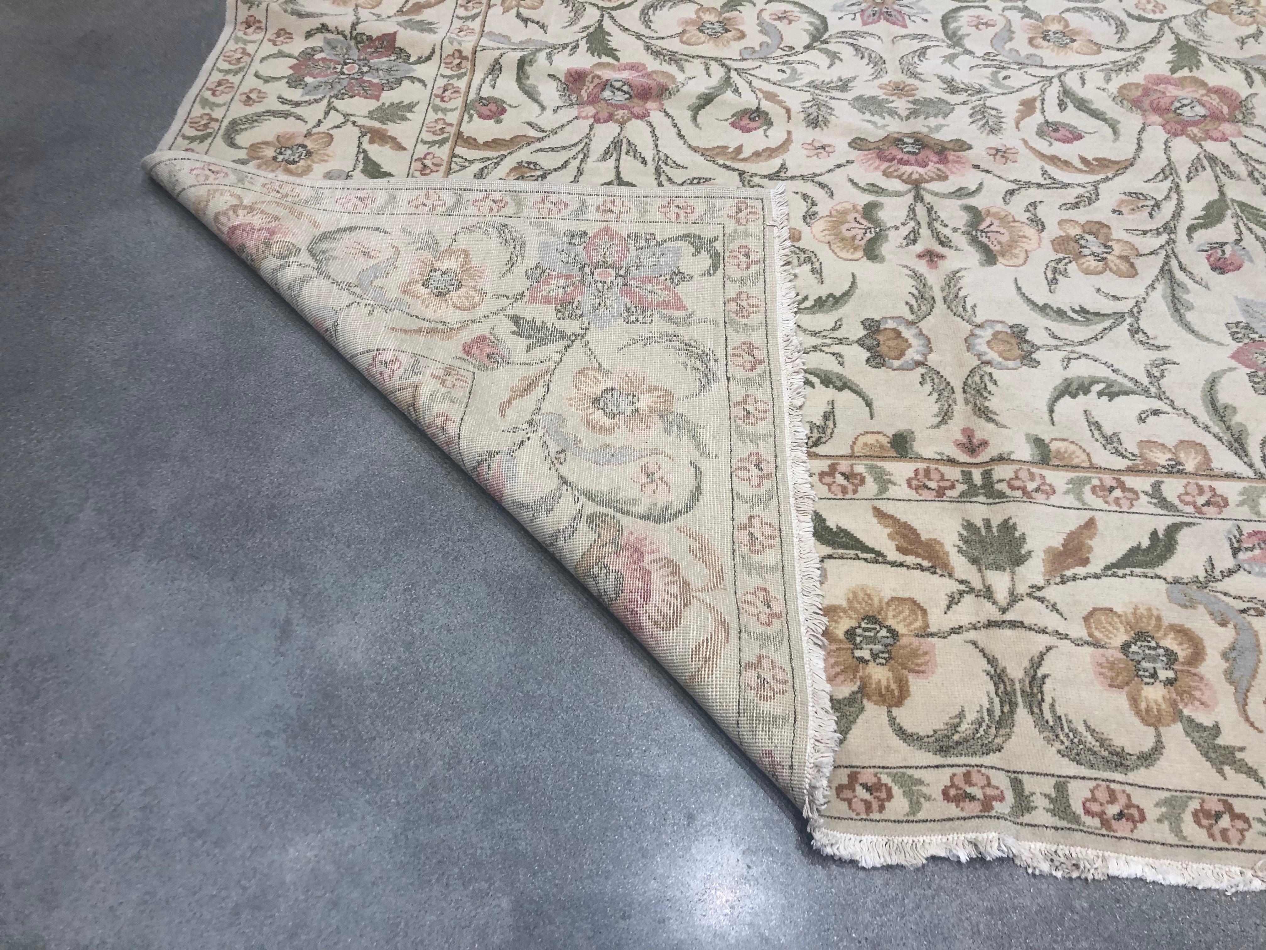 Un bouquet di rosso, oro, argento e verde prende vita in questo tappeto floreale elegante e di buon gusto. Lo sfondo beige fornisce una tela neurale su cui spicca la semplice bellezza dei colori.