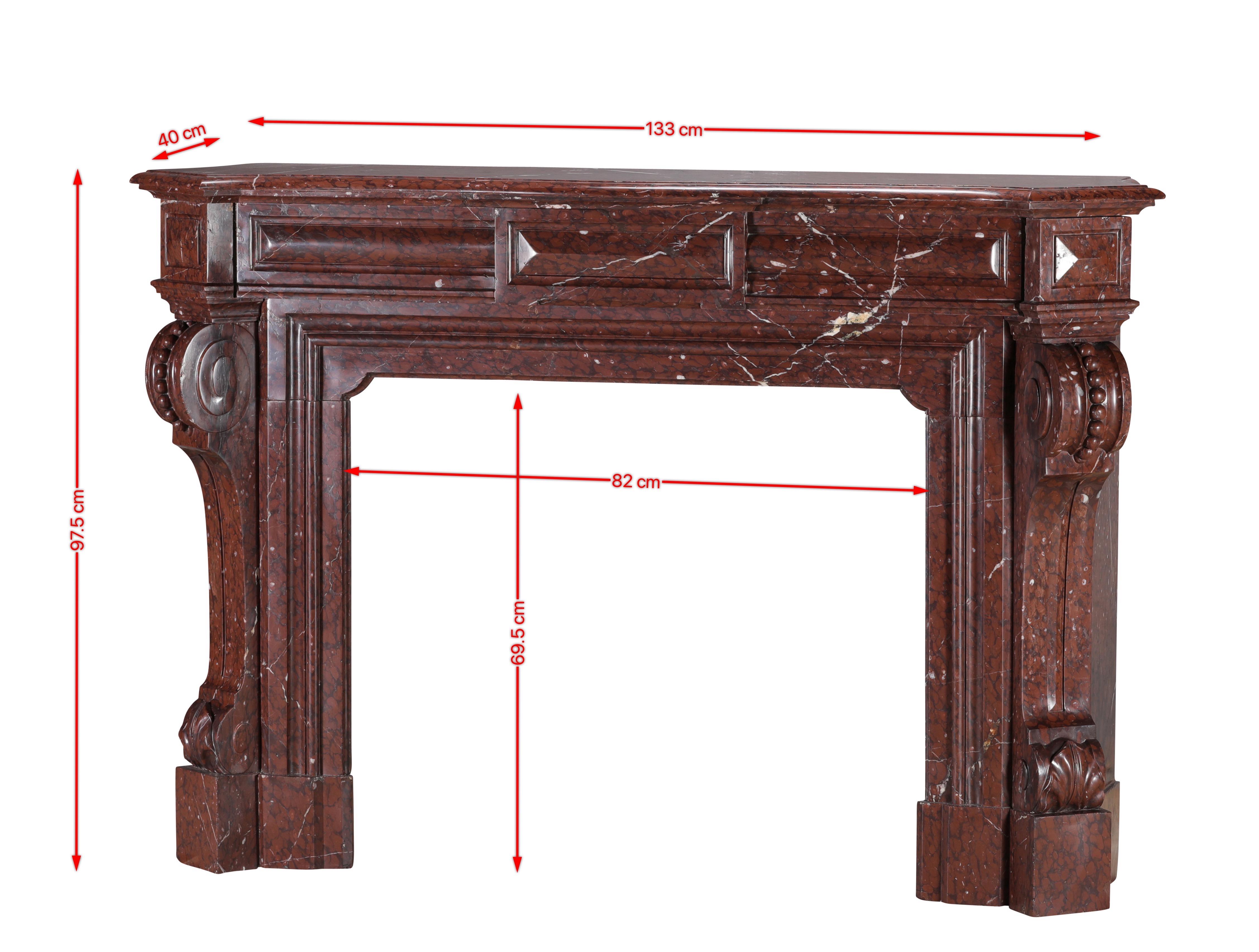 This impressive authentic 19th century French fireplace surround is carved from magnificent Red Griotte marble, a historic stone famously used in the Kings cabinet interior and on the tablettes of the Mazarin commodes at the Château de