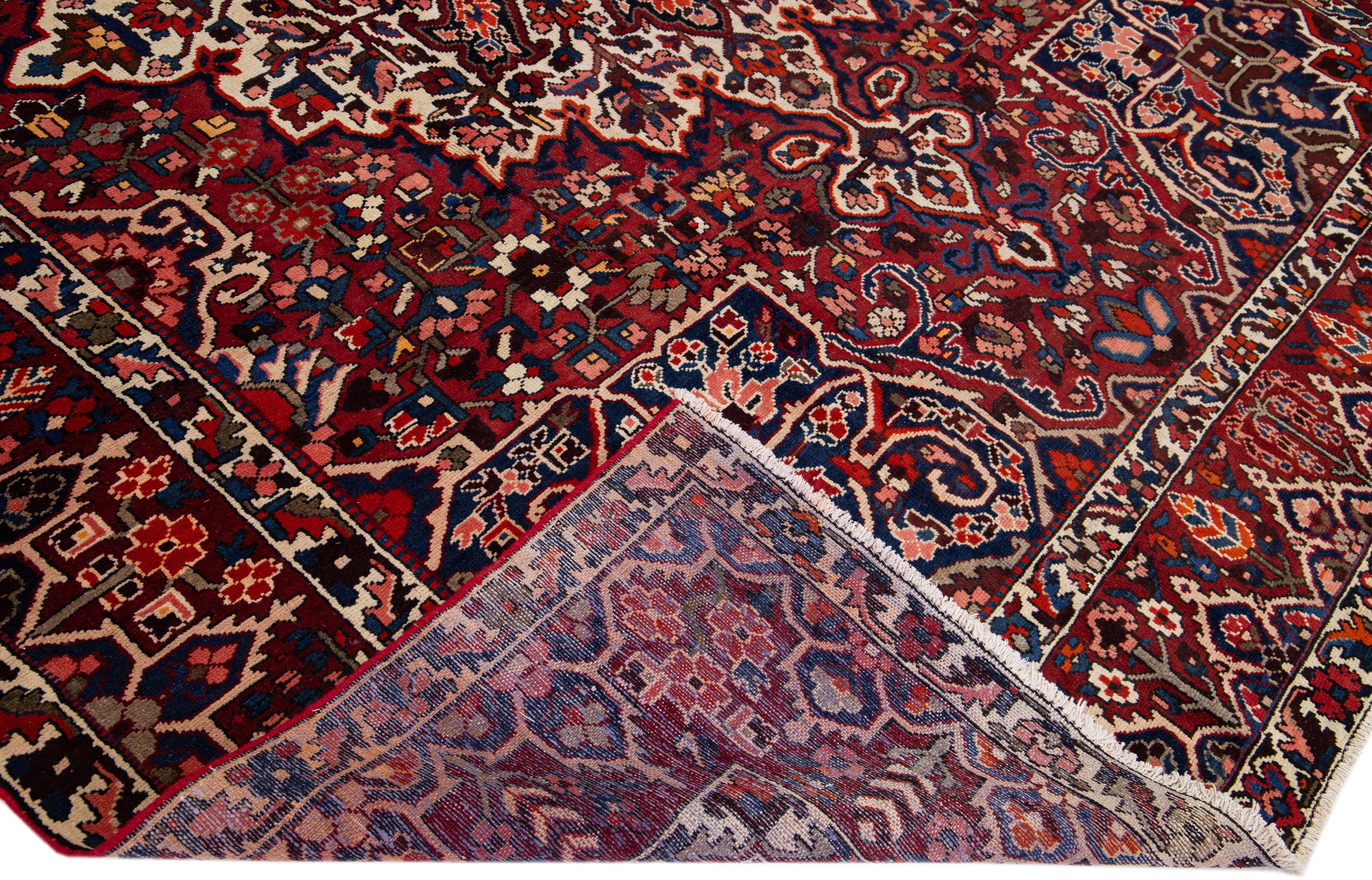 Beautiful antique Bakhtiari hand-knotted wool rug with a red field. This Persian piece has an all-over multicolor accent in a gorgeous classic Medallion motif.

This rug measures 9'11