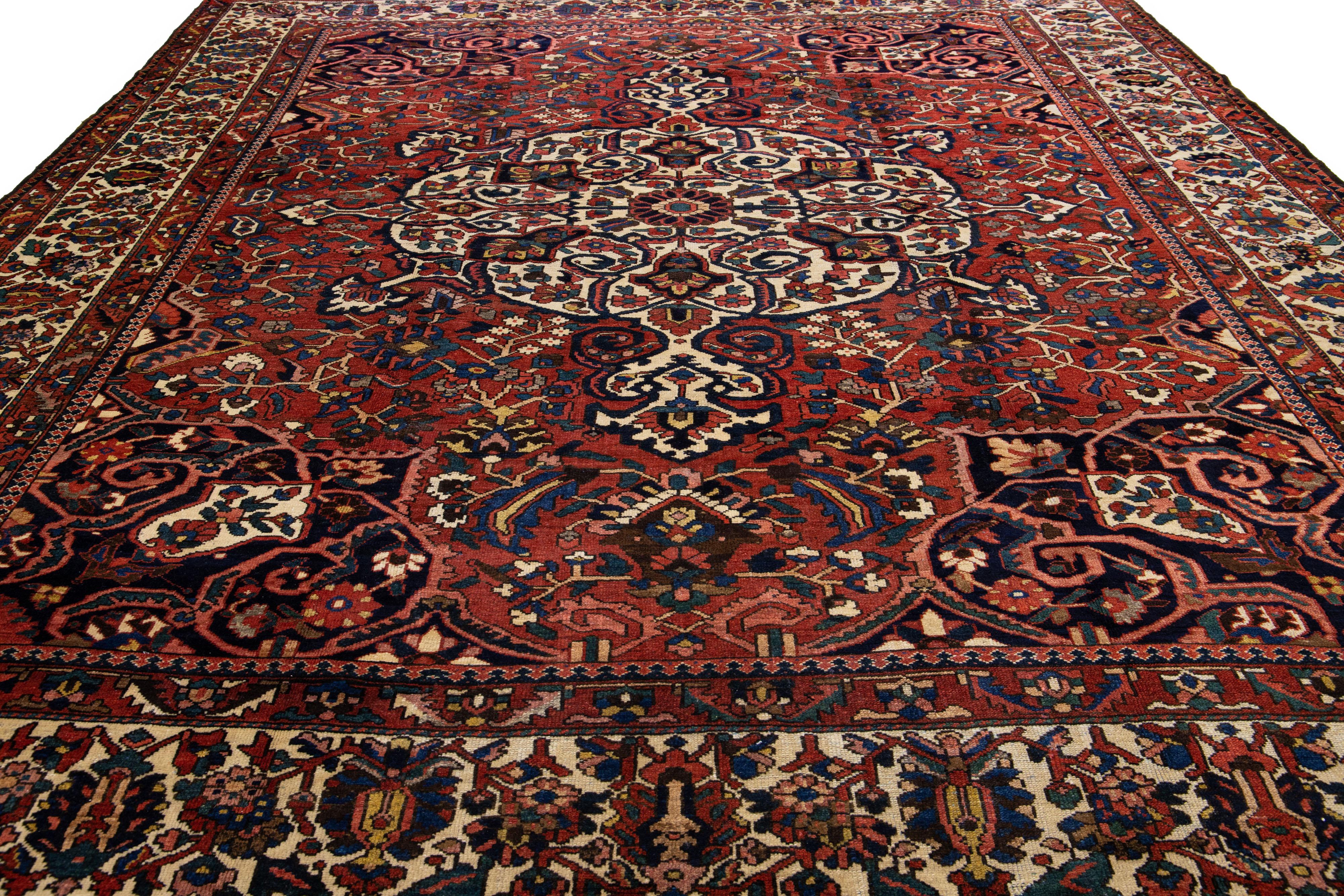 Beautiful Antique Bakhtiari hand-knotted wool rug with a red field. This Persian piece has an all-over multicolor accent in a gorgeous classic Medallion motif.

This rug measures 13'3