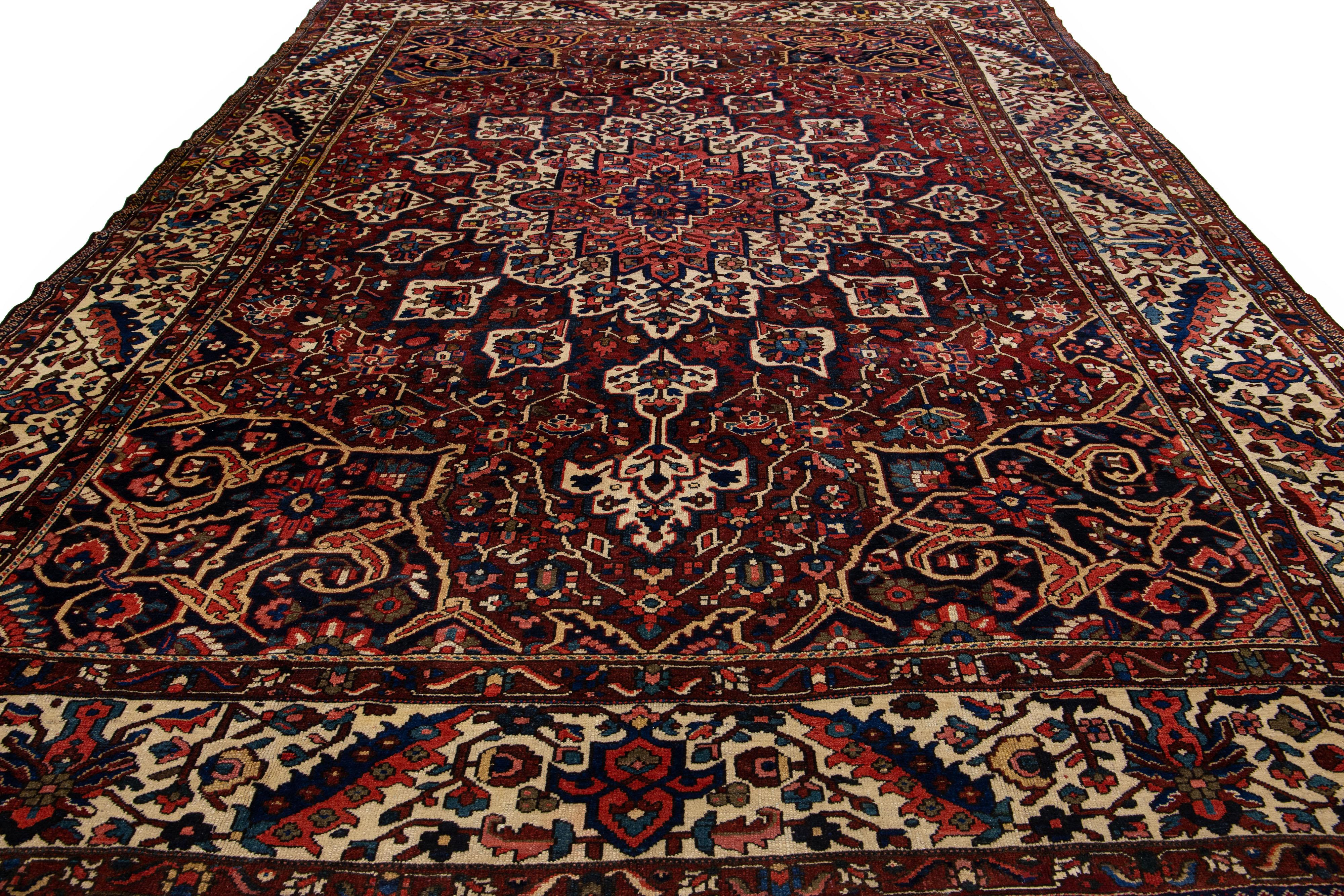 Preciosa alfombra antigua Bakhtiari de lana anudada a mano con un campo rojo. Esta pieza persa tiene un acento multicolor en un precioso motivo de medallón clásico.

Esta alfombra mide 12'1