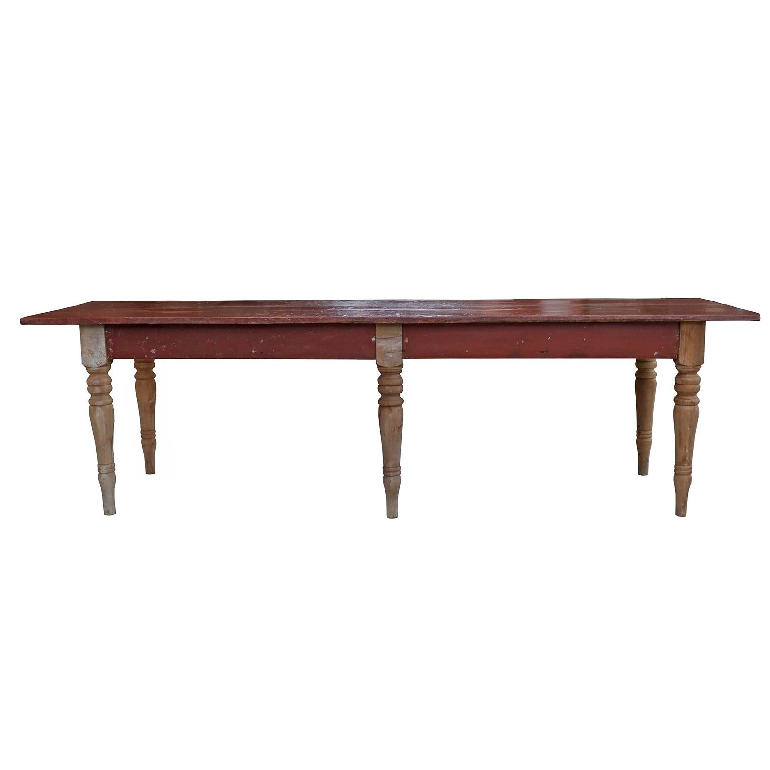 This generously sized table has a bright red top and sturdy turned legs. A great farmhouse aesthetic piece with history and character. Early 20th century.