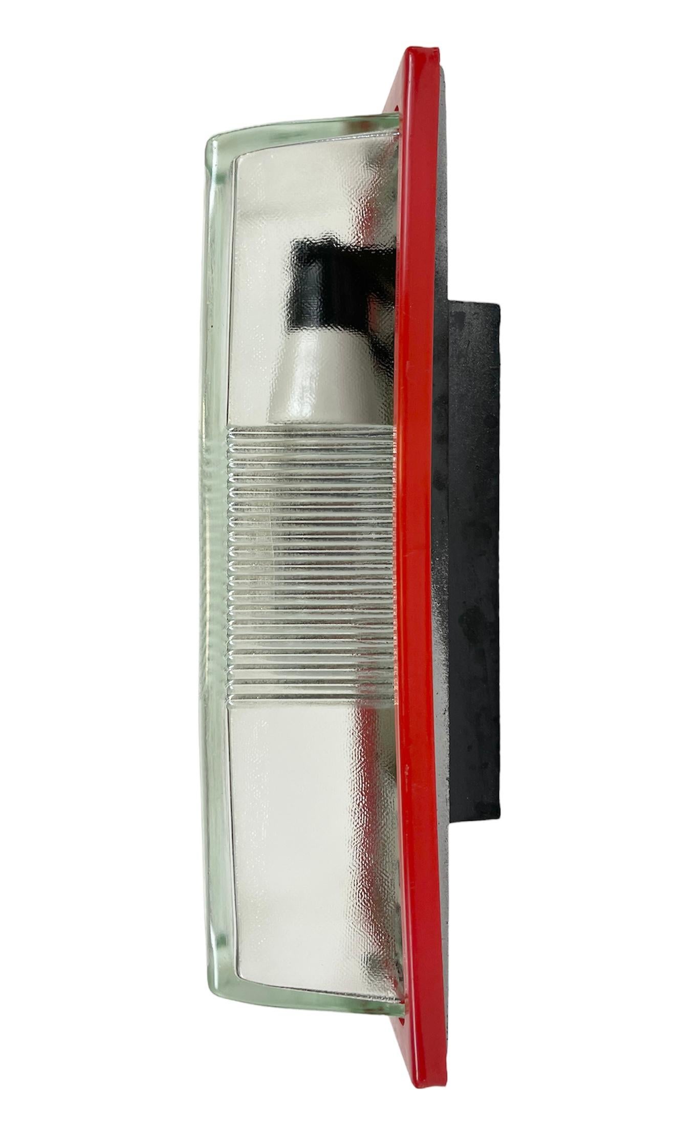 Vintage Industrial wall light made by Elektrosvit in former Czechoslovakia during the 1970s. It features a bakelite body, a red bakelite frame and a glass cover. The porcelain socket requires E 27 light bulbs. New wire. The weight of the light is 2