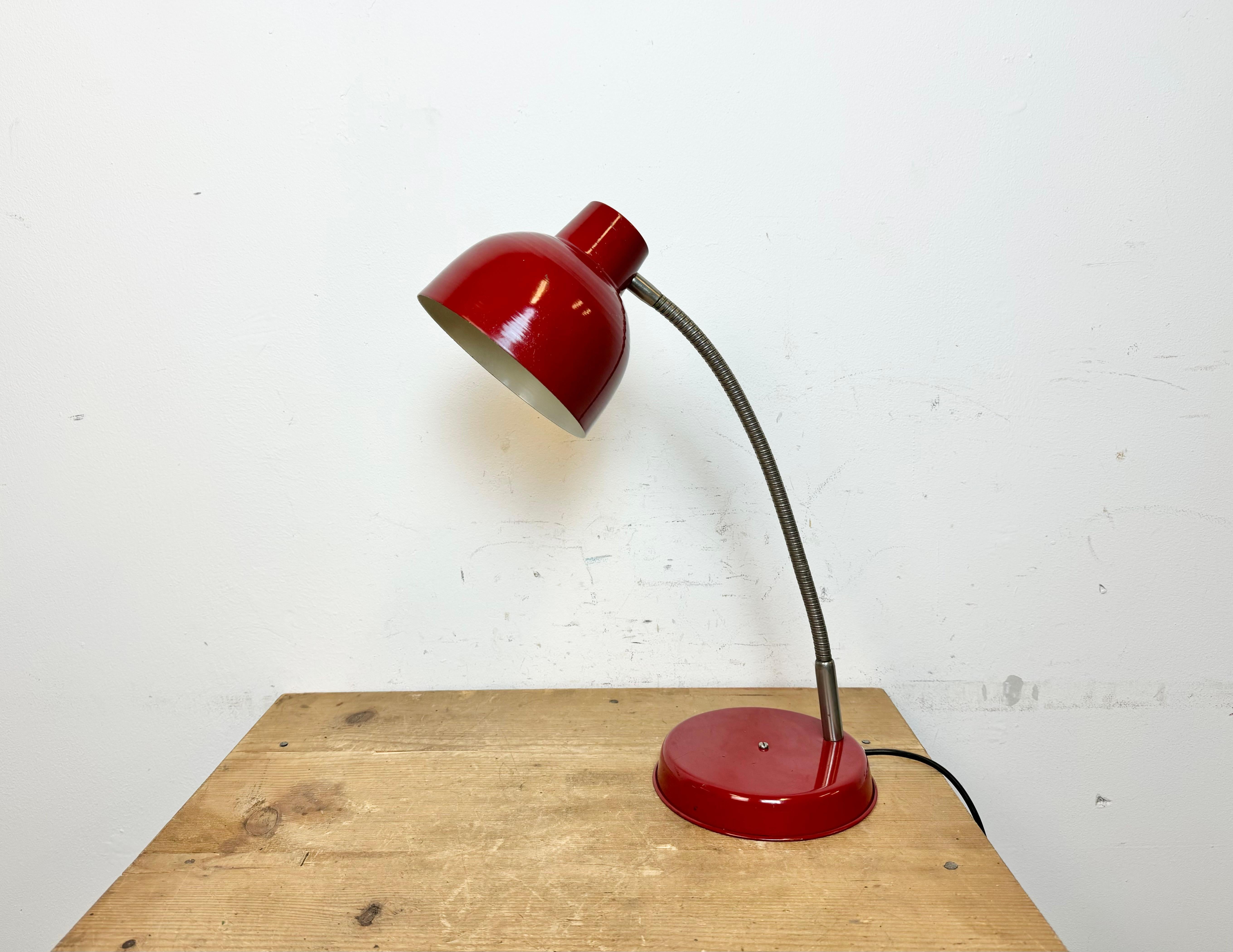 Industrial workshop table lamp made by SRSE in Poland during the 1960s.It features a red metal base and shade and a  chrome plated gooseneck. The original socket requires E27/E26 lightbulbs.
The diameter of the shade is 15 cm. The weight of the lamp
