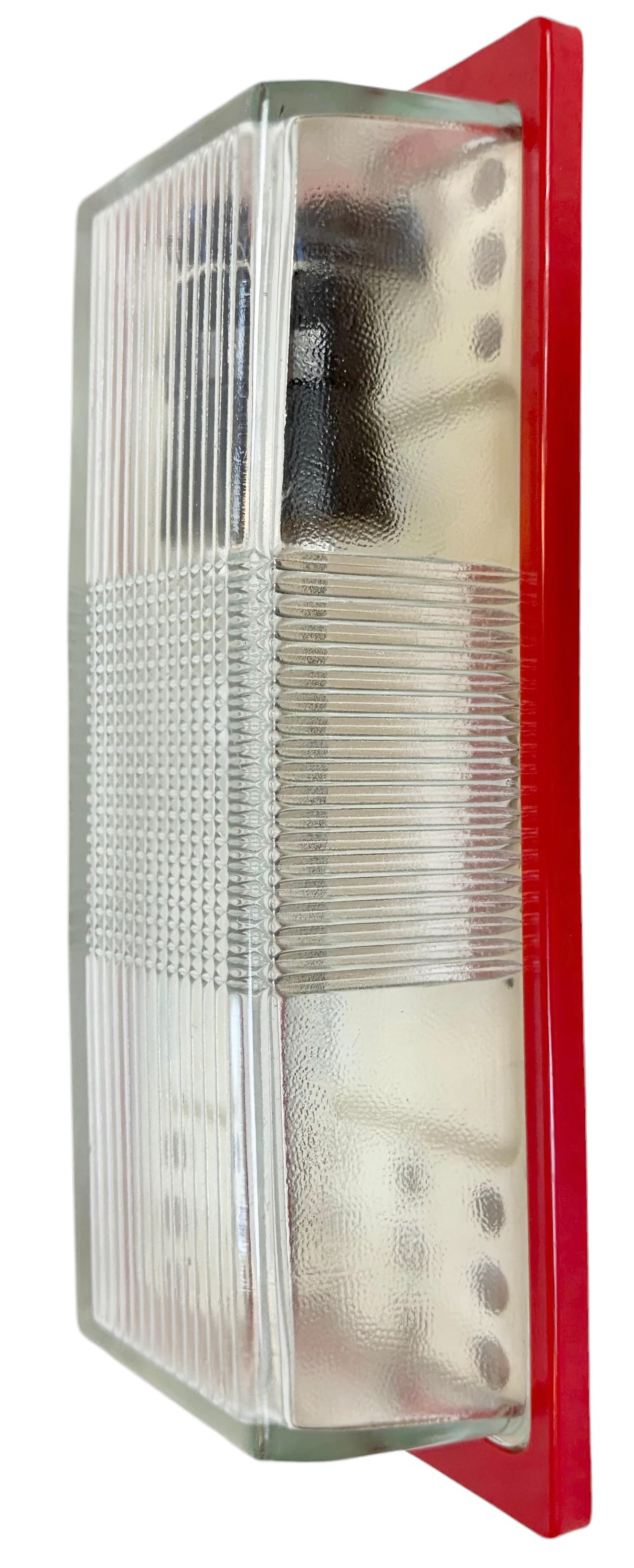 Applique murale industrielle vintage fabriquée par Elektrosvit dans l'ancienne Tchécoslovaquie au cours des années 1970. Il comporte un dos en métal, un cadre en bakélite rouge et un couvercle en verre. La douille en porcelaine est compatible avec