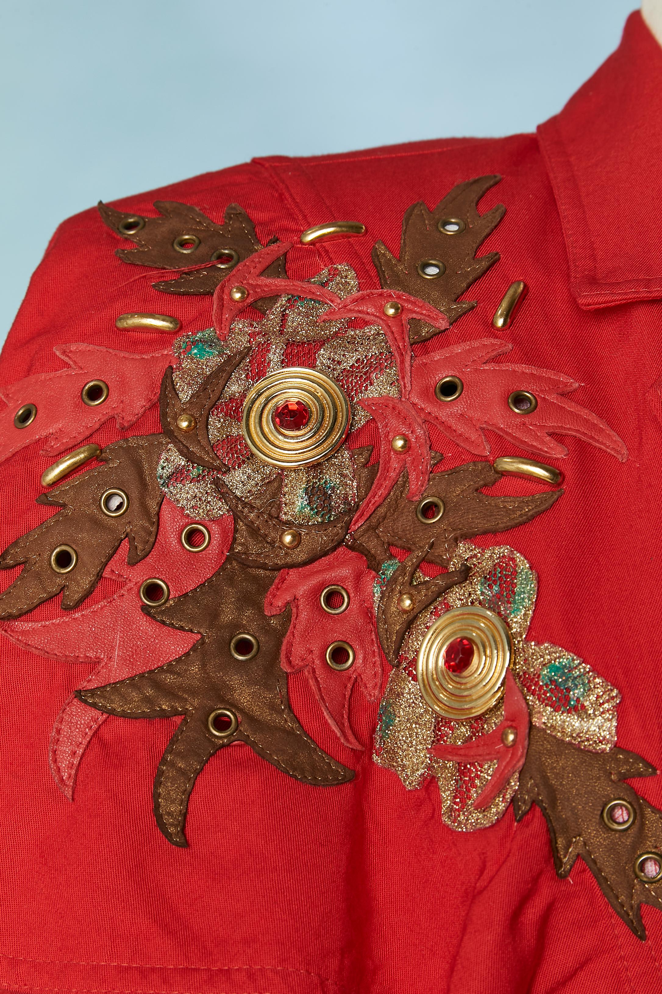 Red jacket with mini cape and leather and eyelet appliqué. Main fabric: 100% rayon. Lining: rayon or acetate. SHOULDER PADS. Buttons are covered in the same fabric. 
SIZE: M 