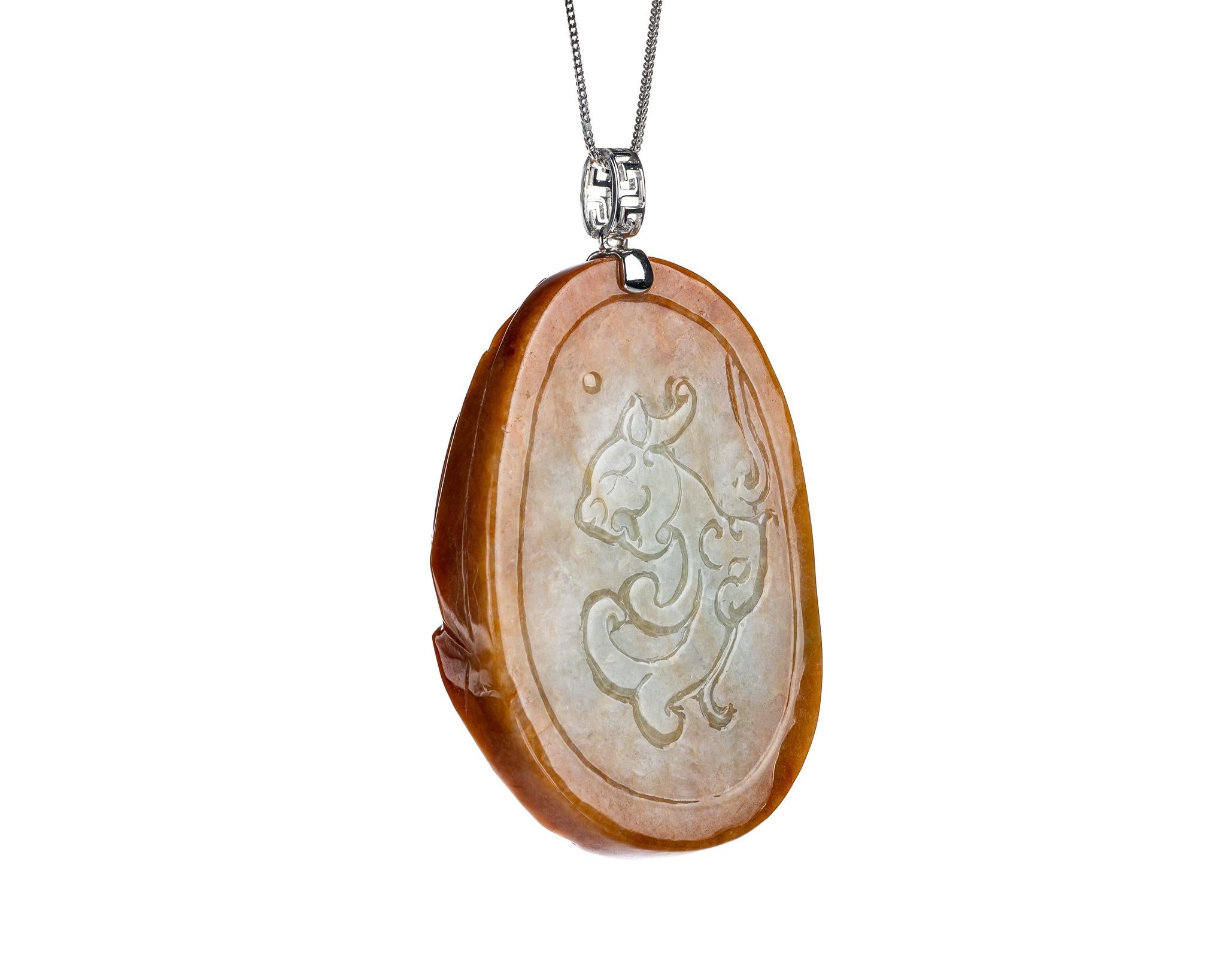 This is an all natural, untreated jadeite jade carved tiger pendant set on an 18K white gold bail.  The carved tiger symbolizes great power, courage and personal strength. 
  
It measures 1.78 inches (45.3mm) x 2.56 inches (65mm) with thickness of