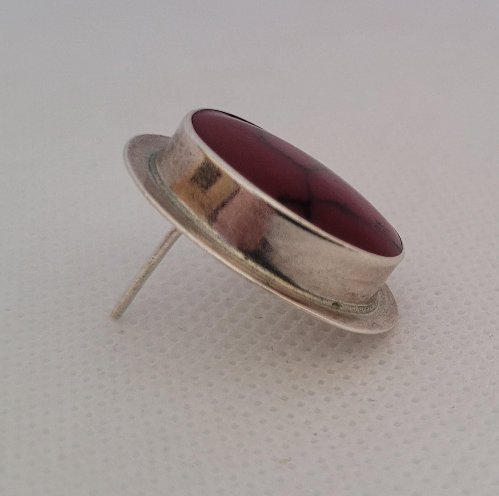 Oval red jasper 925 silver full-bezel friction post earrings. The earrings are 25mm x 20mm in size and weigh 11 grams. They are stamped ATI designer, Mexico 925. The red jasper inlay measures 19mm x 15mm x 6mm. These earrings feature a rich deep red