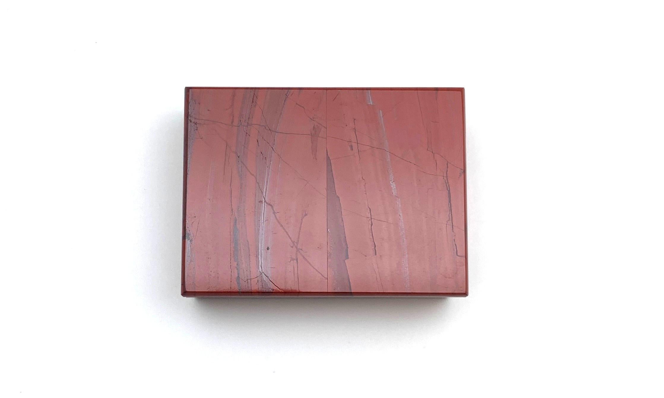 This decorative box of marbled red jasper looks like the finest lacquer, but is completely natural! An opaque variety of chalcedony, red jasper is said to increase self-confidence. The interior of the box is fashioned from alabaster, a stone