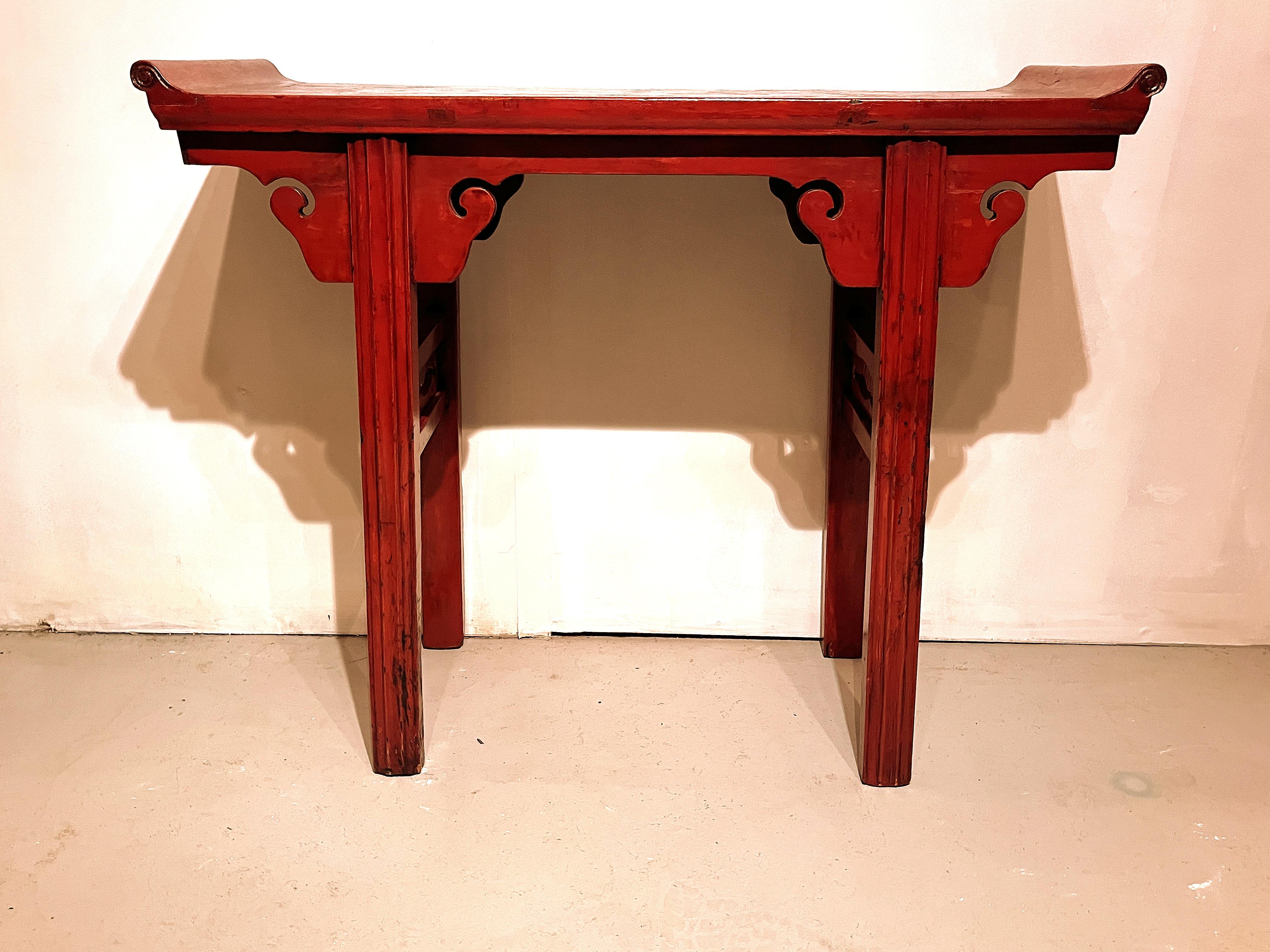 Table d'autel en laque rouge avec rebords évasés.